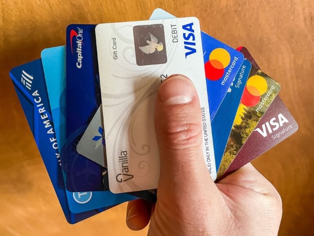 Man holding a bunch of travel credit cards in his hand to help with trip planning