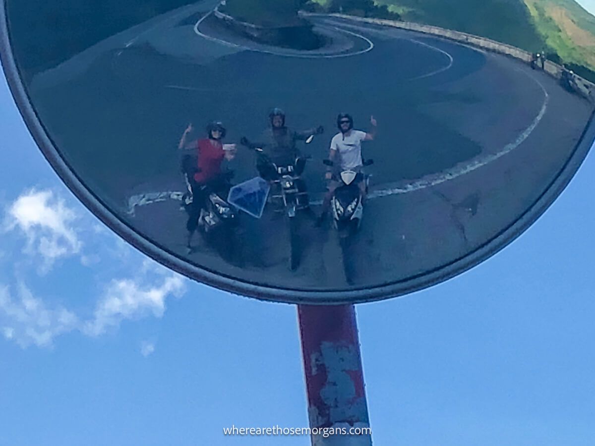 Three people posing for a photo along the hairpin curve on the Hai Van Pass