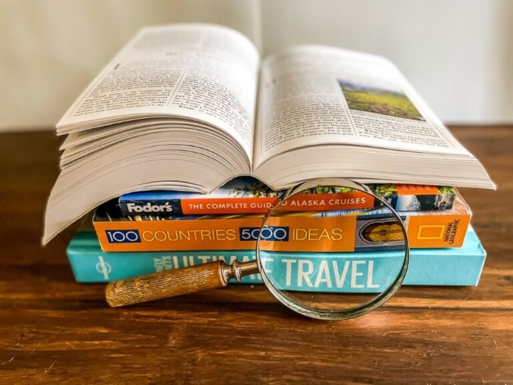 Pile of travel books stacked on top of each other for trip planning