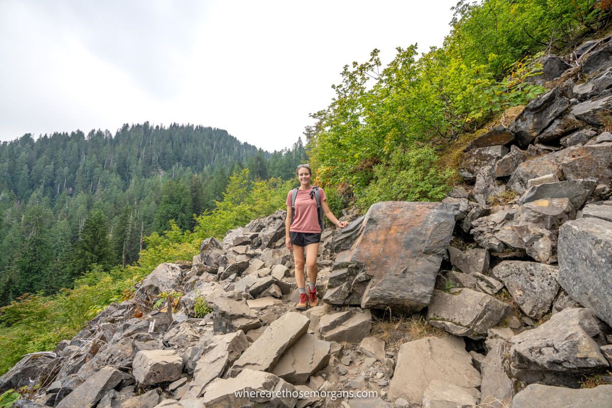 Photo of a person standing in the middle of a steep boulder field on the side of a mountain