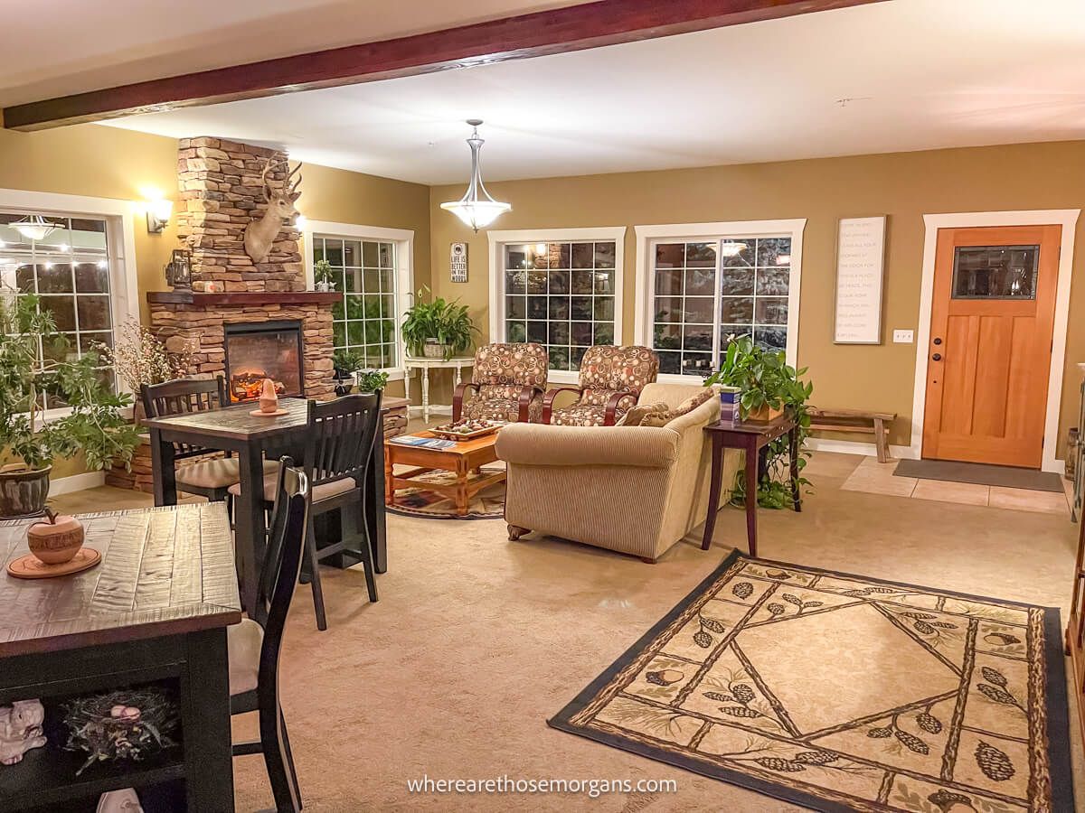 Photo of the inside of a bed and breakfast in Leavenworth Washington with a rug, sofas, table and chairs, fireplace and lots of lighting