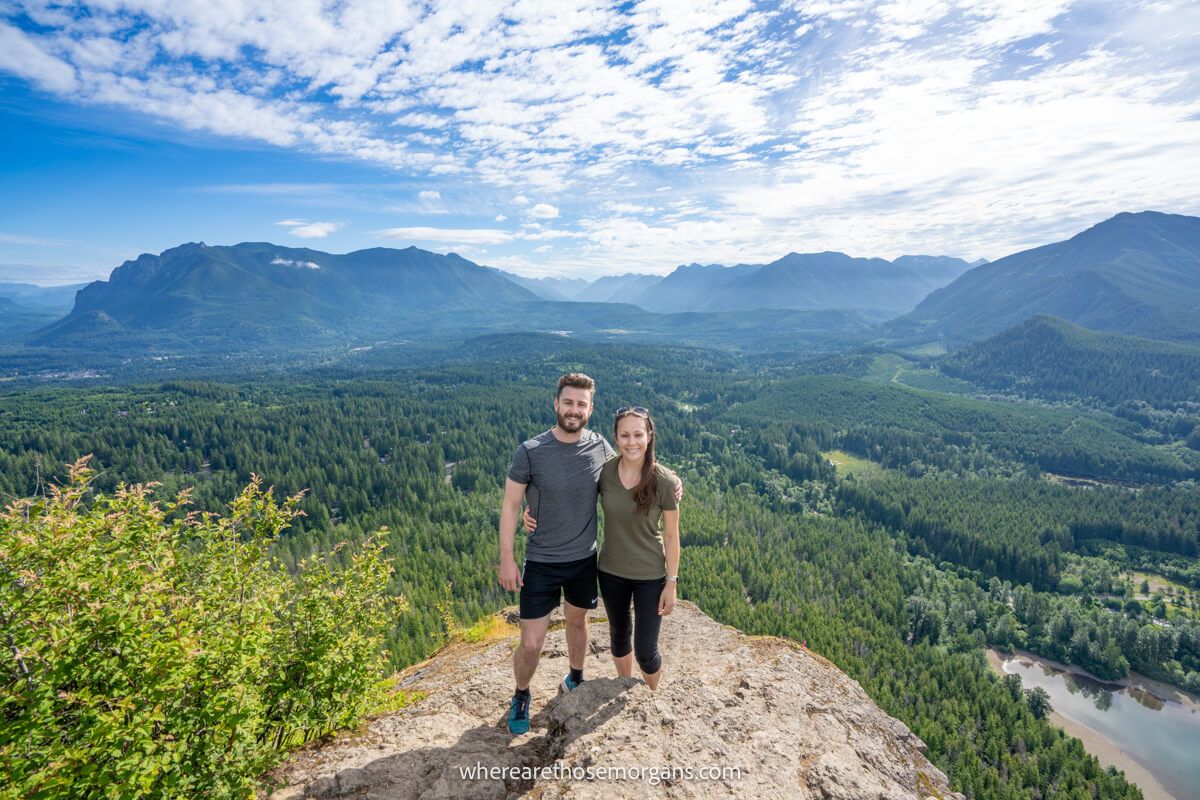 Photo of Mark and Kristen Morgan from Where Are Those Morgans stood together at the summit of Rattlesnake Ledge Trail near Seattle, Washington on a sunny day