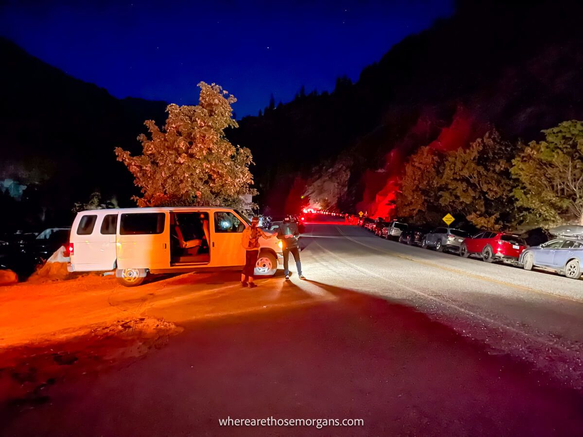 Photo of Snow Lakes Trailhead in Washington in the dark with cars parked on the roadside and a white minivan picking up hikers