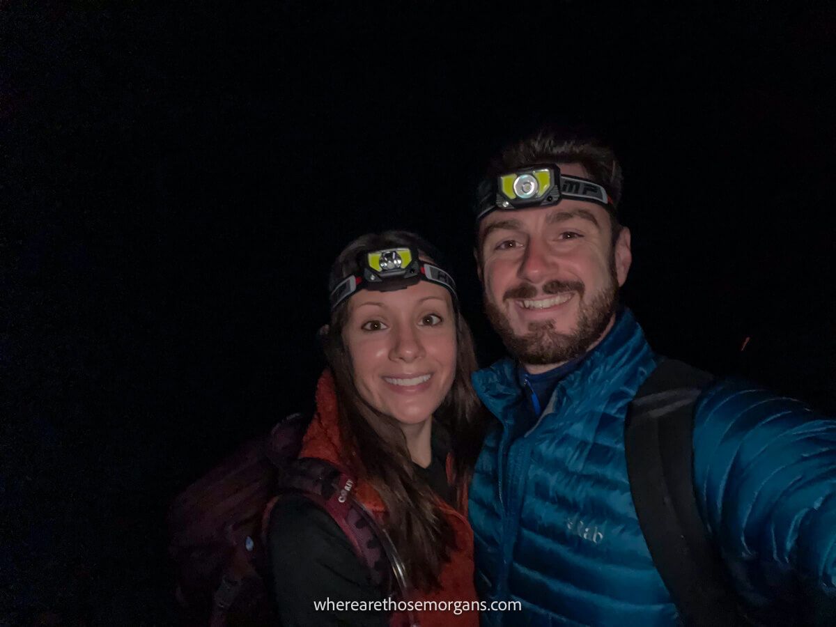 Photo of Mark and Kristen Morgan from Where Are Those Morgans taken in the dark with down jackets and headlamps on at the beginning of The Enchantments hike in Washington