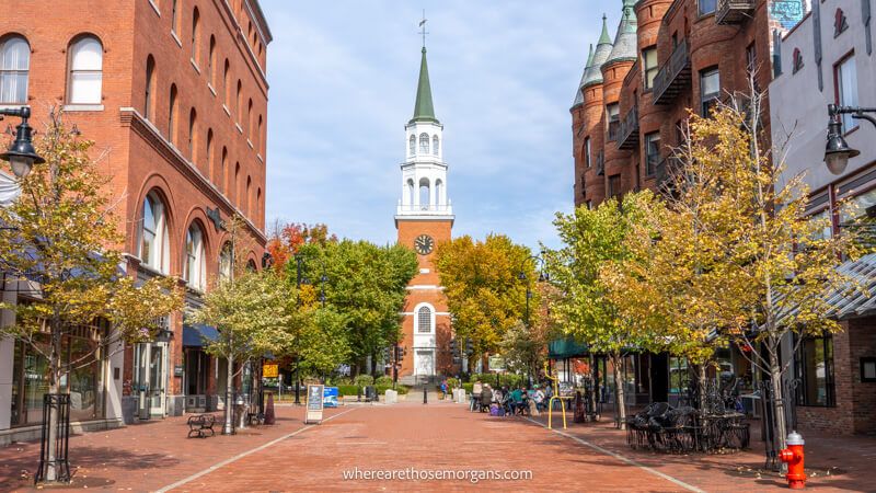 Photo of a cobbled brick pedestrian road with buildings to either side leading to a church at the far side of the path