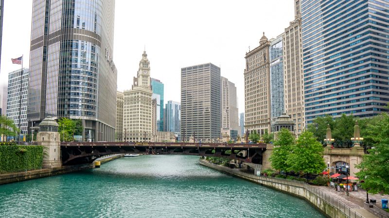Photo of a river leading to a bridge and skyscrapers in Chicago