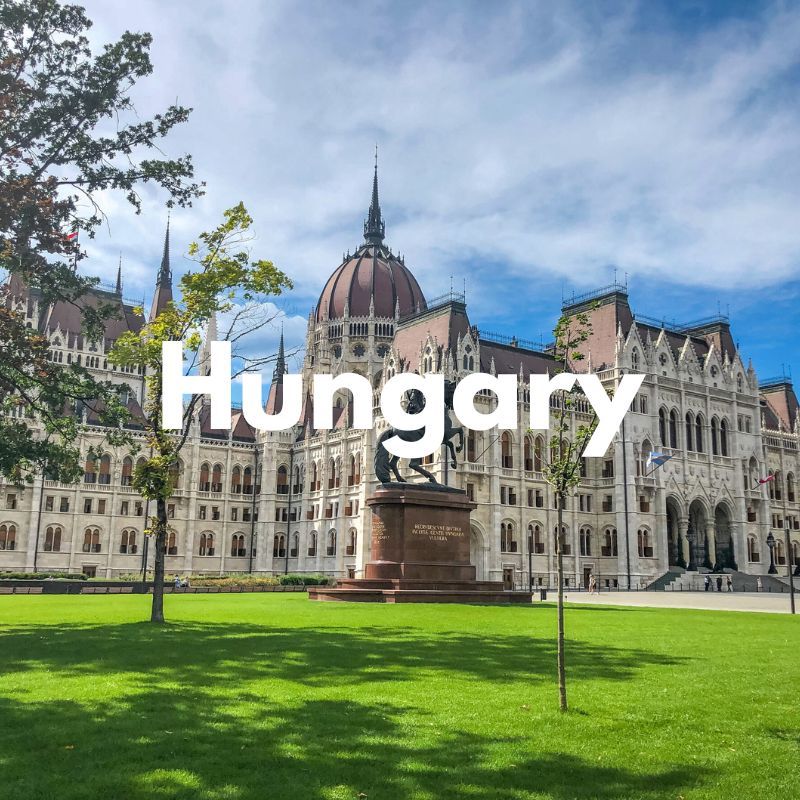 Photo of grass leading to a large parliament building with the word Hungary overlaid