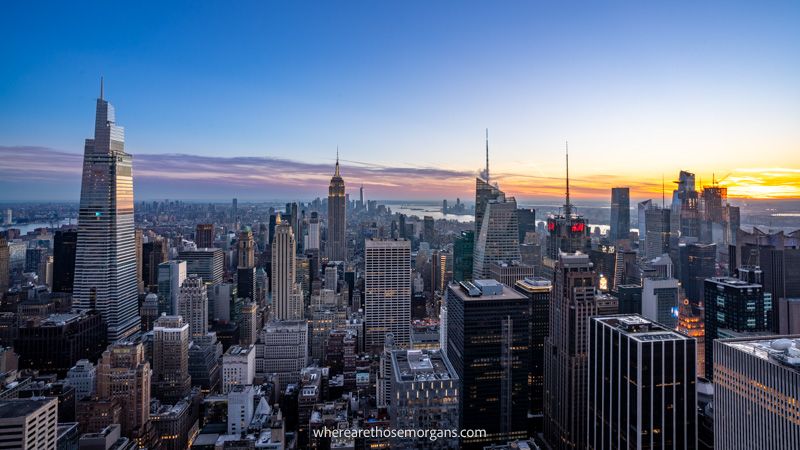 Photo of the NYC skyline taken from the top of an observation deck at sunset