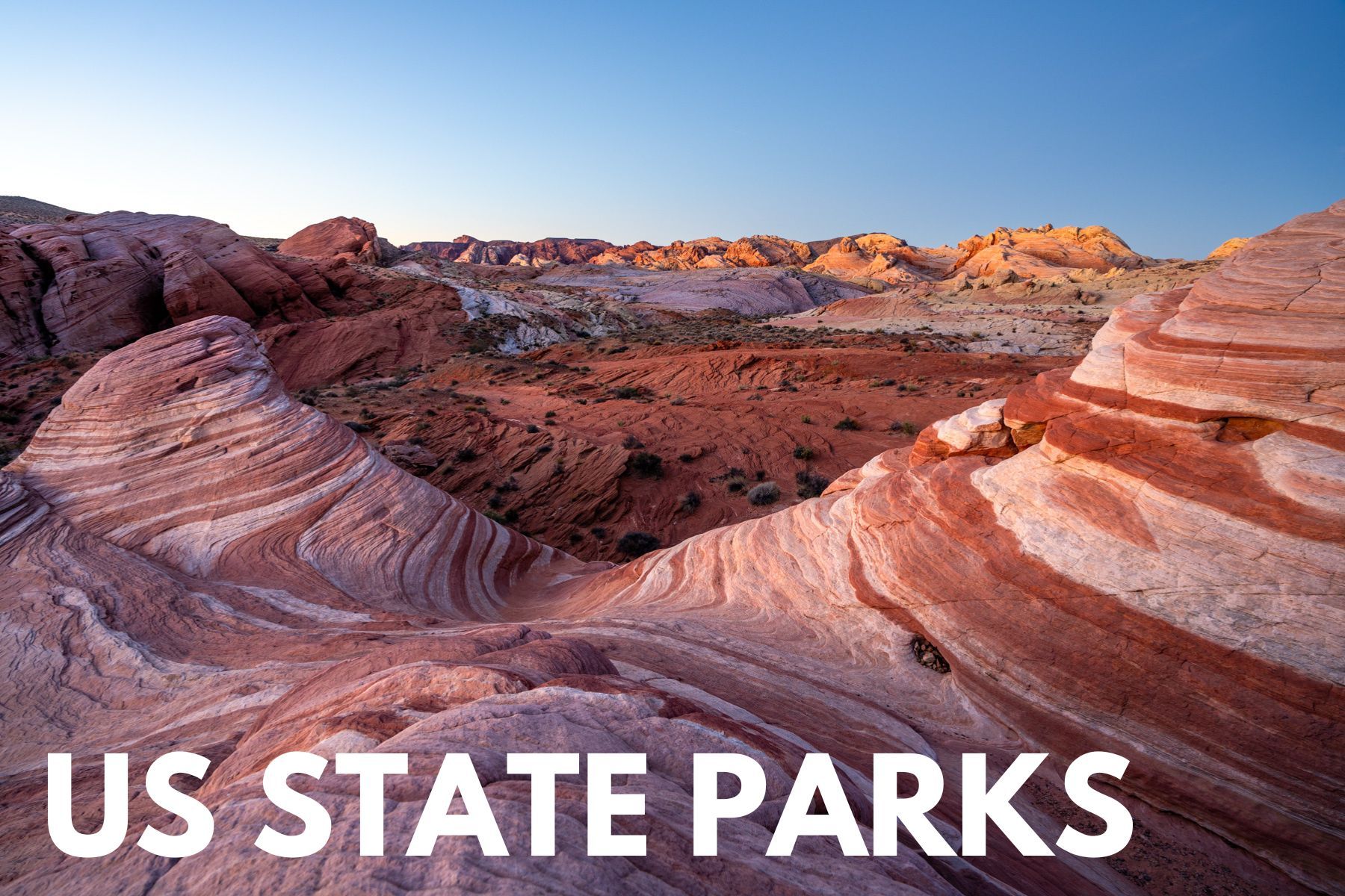 Photo of a sandstone landscape with swirling red and white sediment layers on domed formations at dawn with the words US state parks overlaid