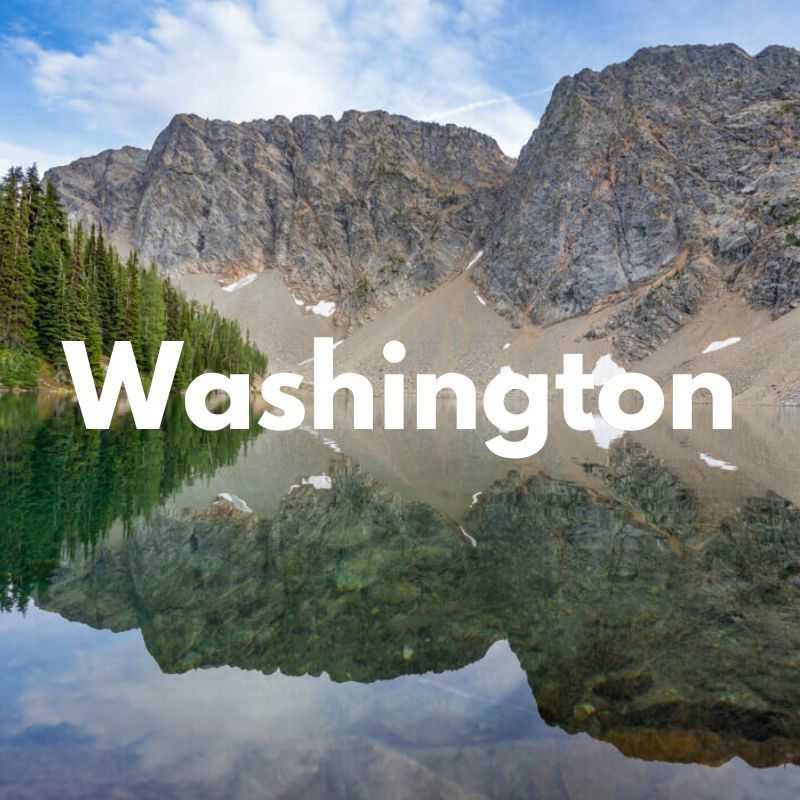 Photo of a still lake reflecting granite mountains and trees with the word Washington overlaid