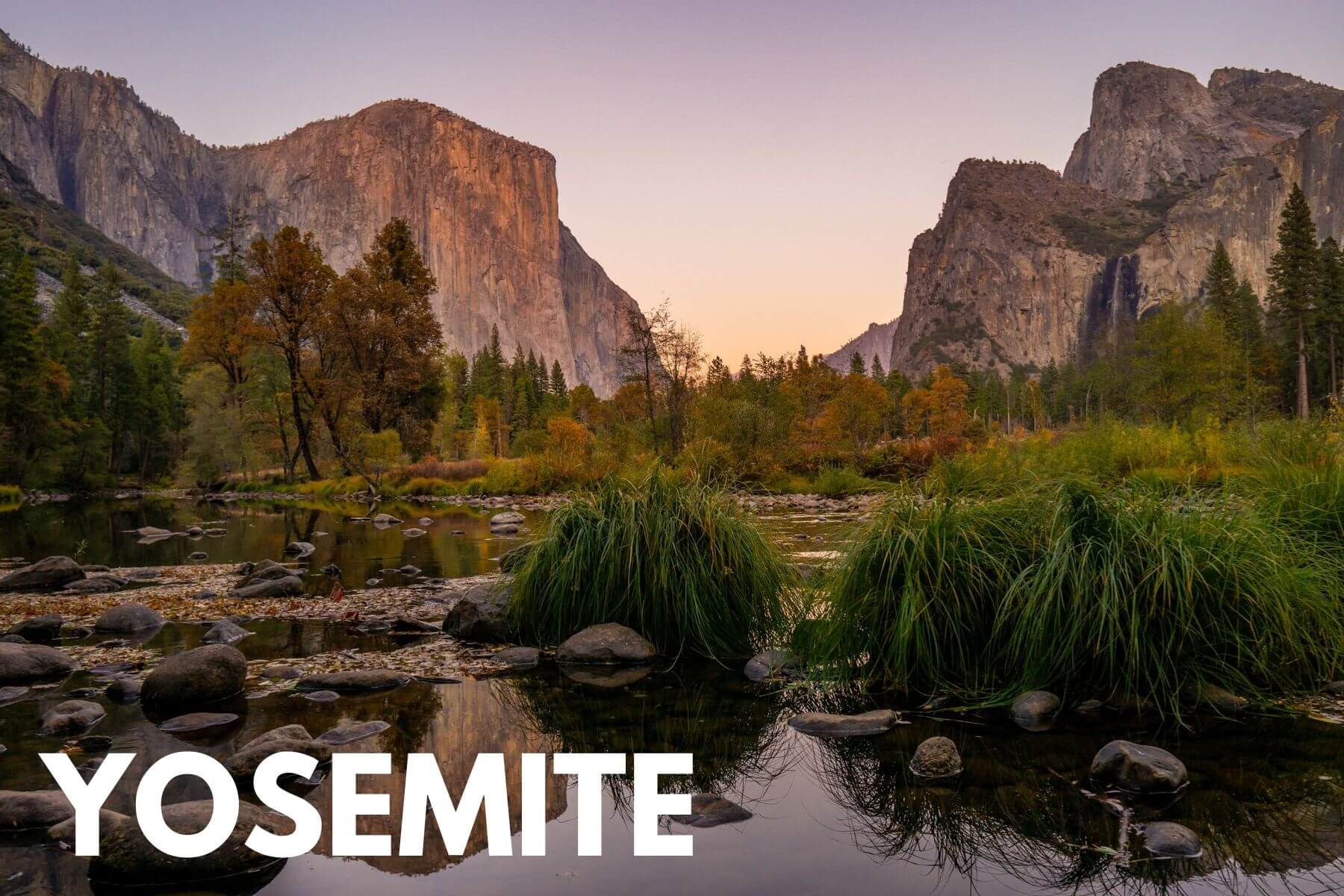 Photo of a river with vegetation growing leading to a wide open meadow and towering granite rock formations inside a national park at sunset with the word Yosemite