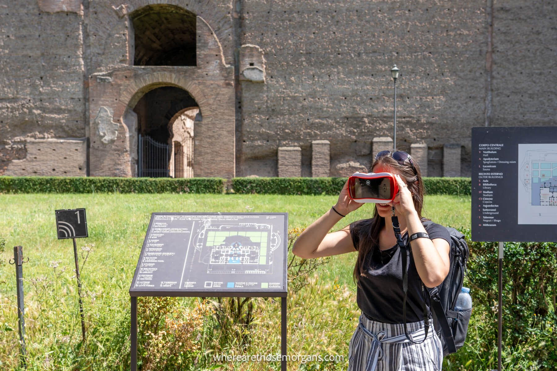 Photo of a tourist in a Roman ruin holding up a pair of VR goggles