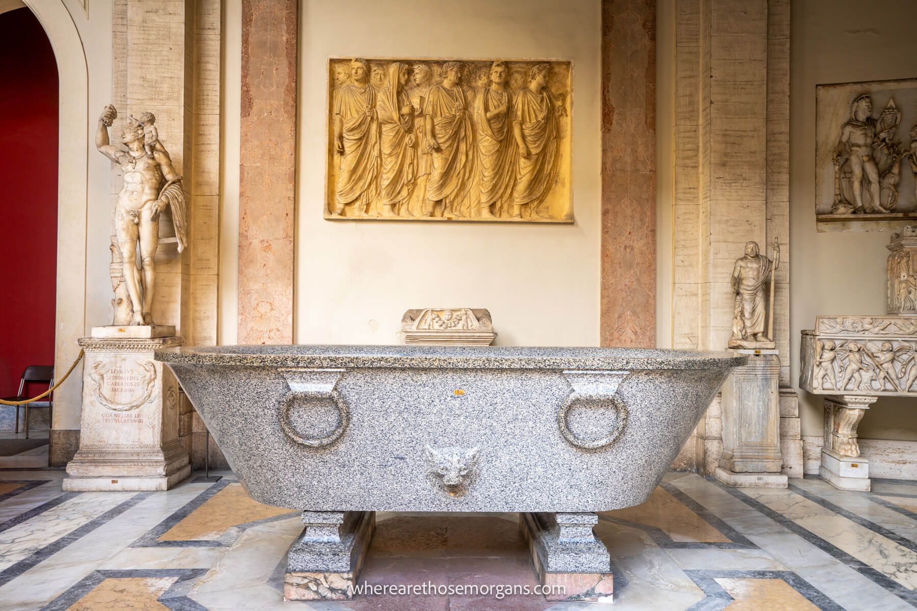 Photo of a stone bathtub on a marble floor inside the Vatican Museum