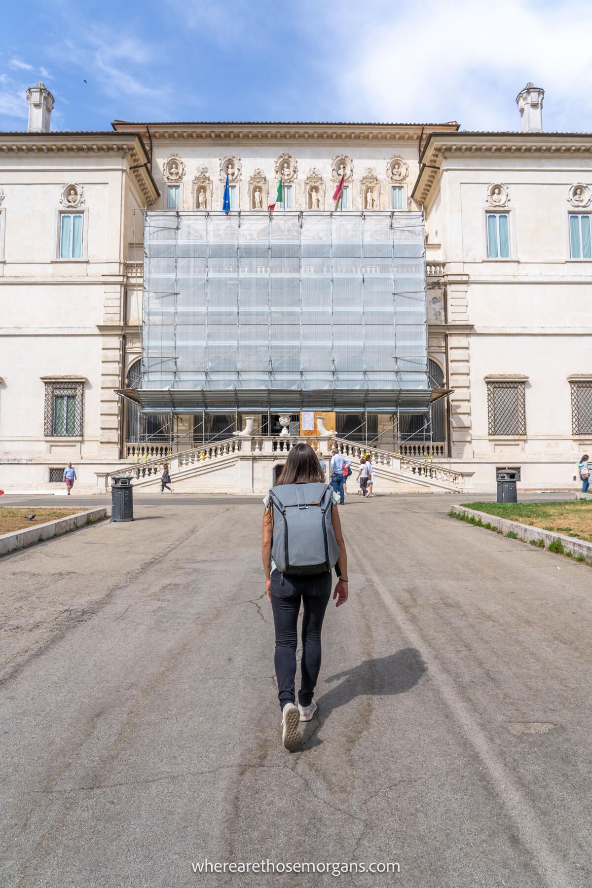 Photo of a tourist walking up to the Borghese Gallery in Rome on a sunny day