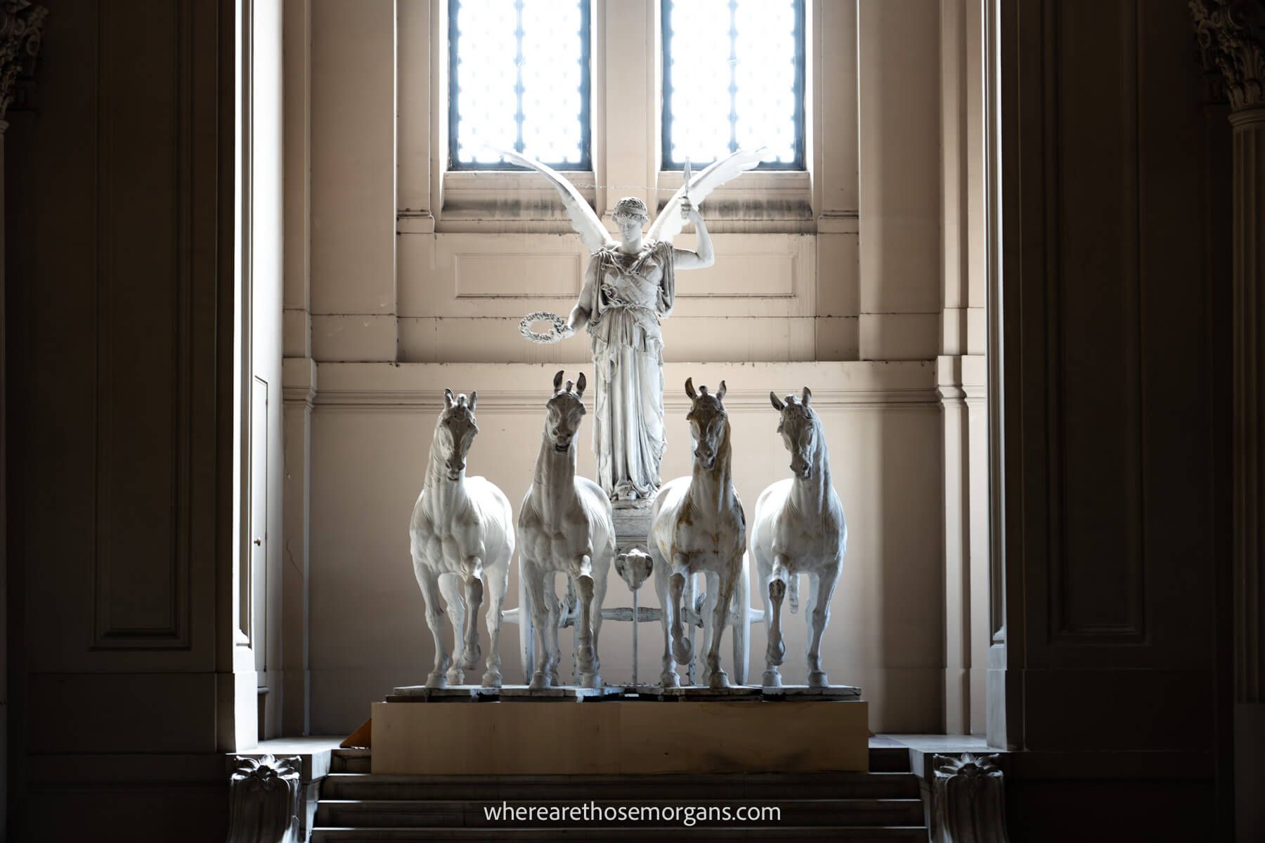 Photo of four horses and an angel in front of a window letting light into an otherwise dark room at the Monument to Victor Emanuele II in Rome