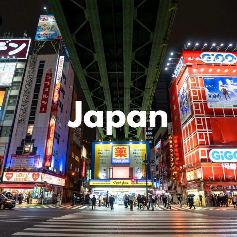 Photo of a pedestrian crossing with people walking across at night next to tall buildings with vibrant colors and a bridge passing overhead with the word Japan overlaid