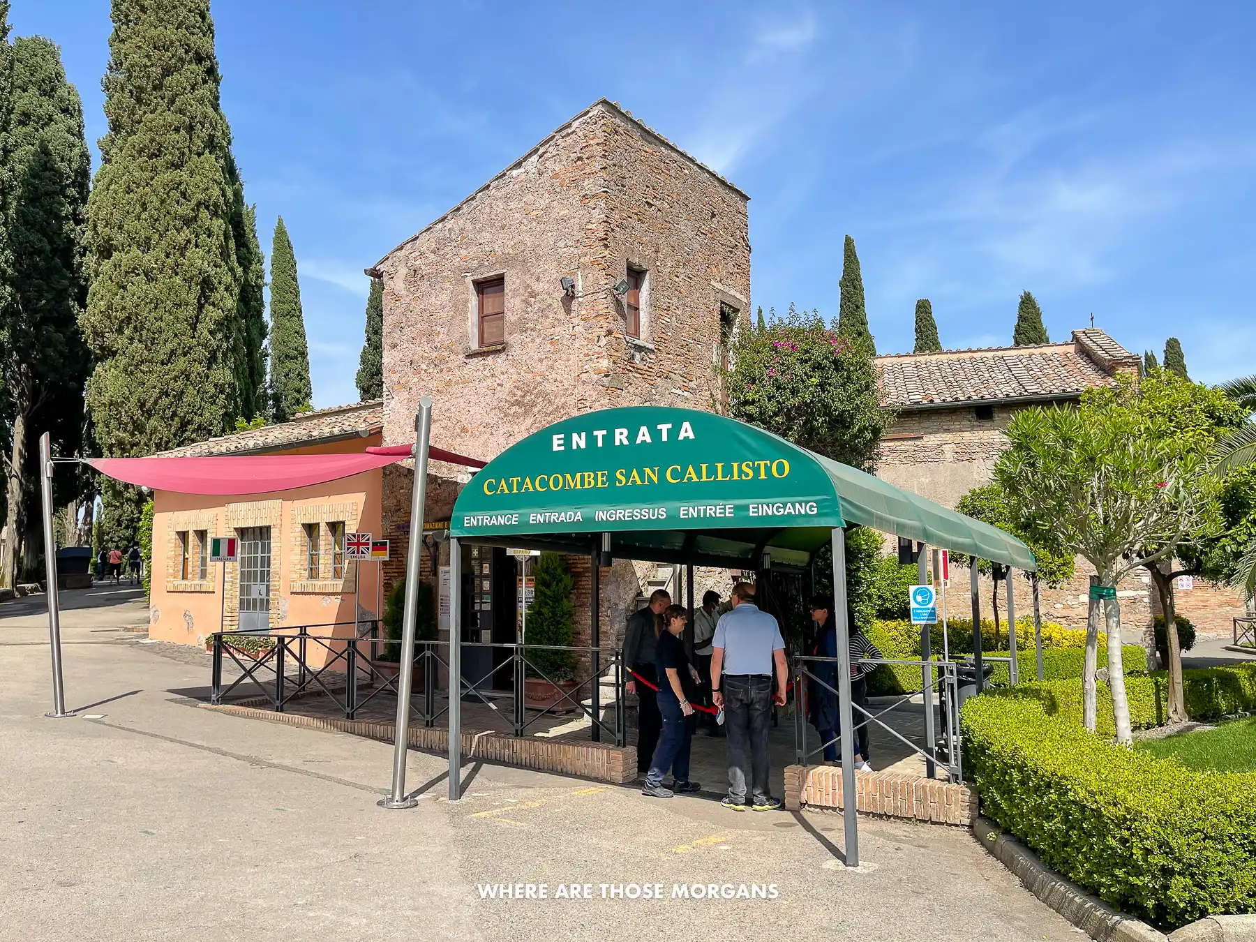 Entrance to catacombs in Rome with a green veranda offering shade at the ticket station