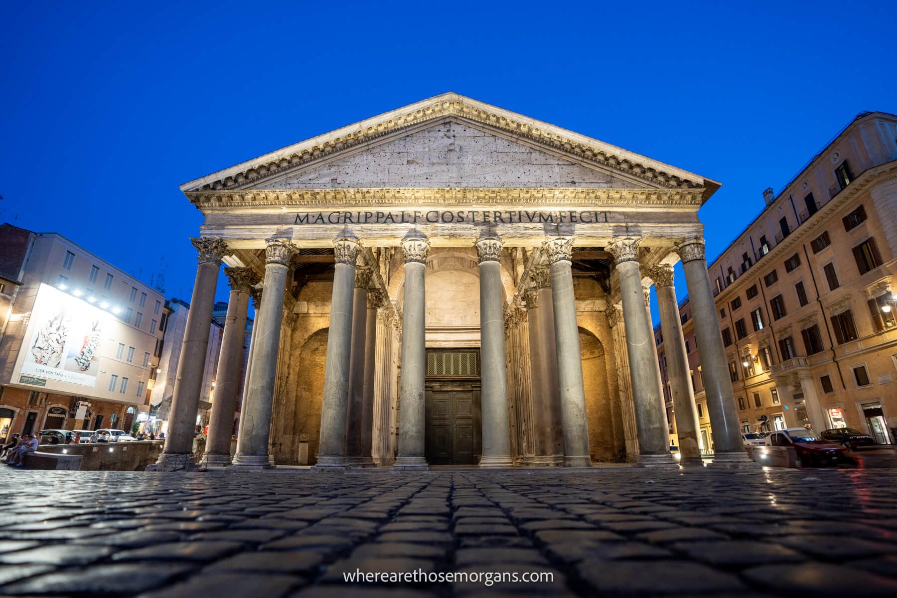 Photo of the Pantheon lit up at night with a deep blue sky and no tourists in the piazza