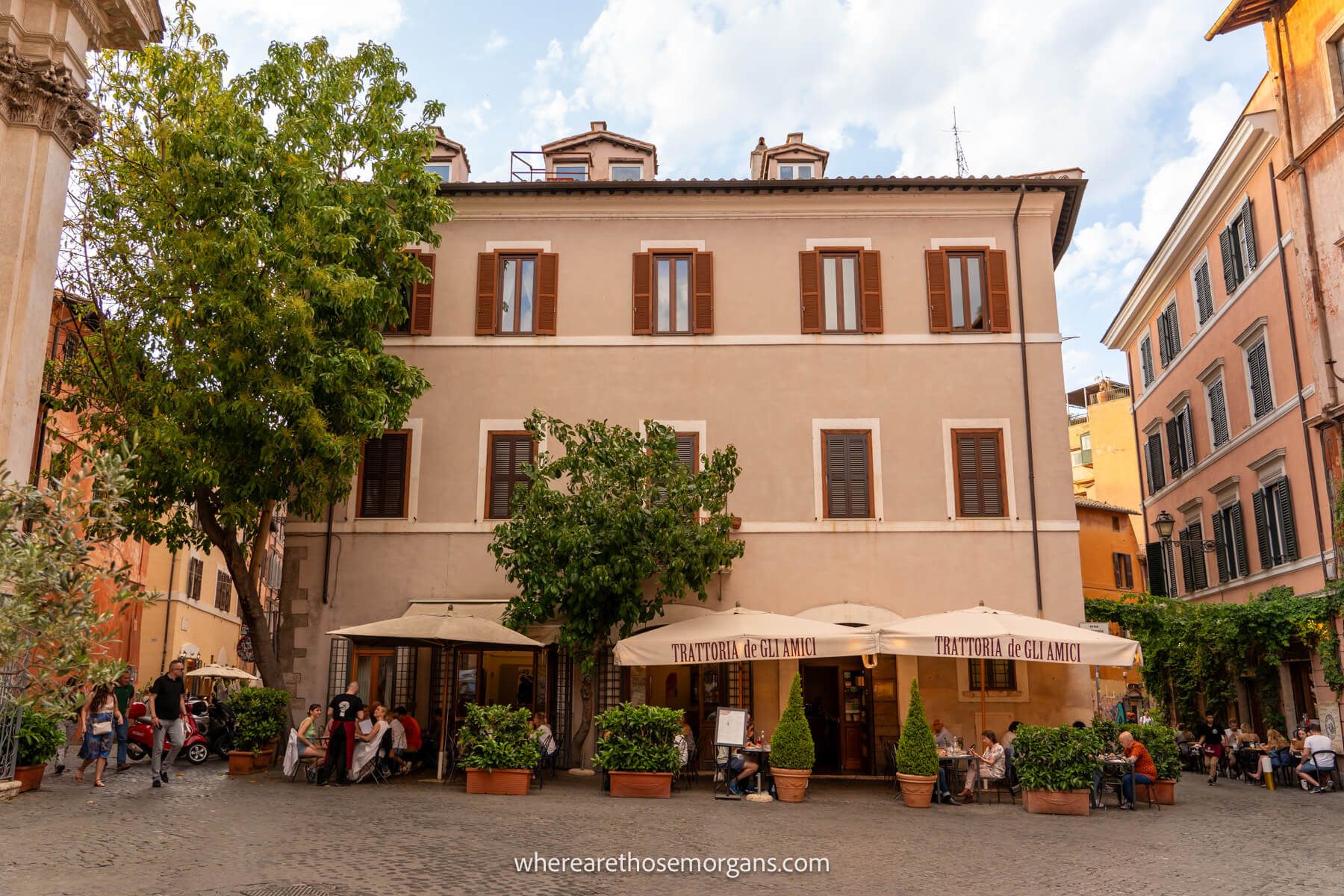 Photo of the outside of a restaurant with outdoor seating in a cobbled plaza in Trastevere Italy