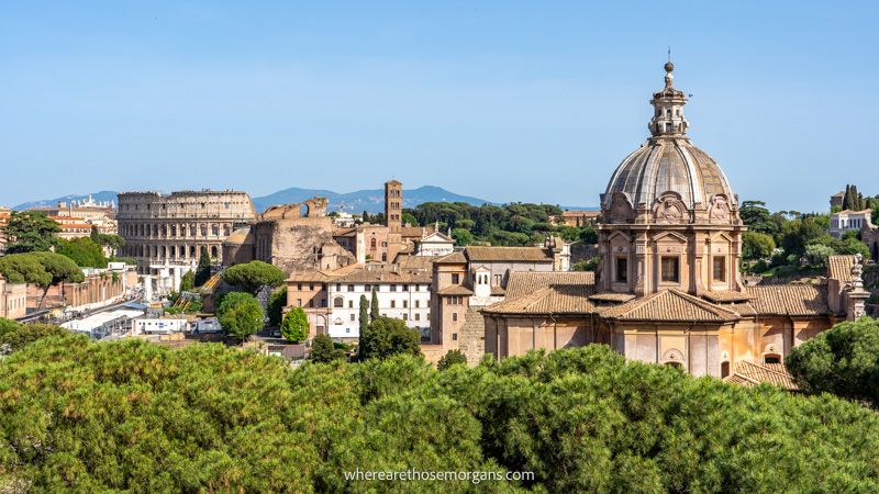 Photo of Rome's ancient buildings over green bushes on a clear day