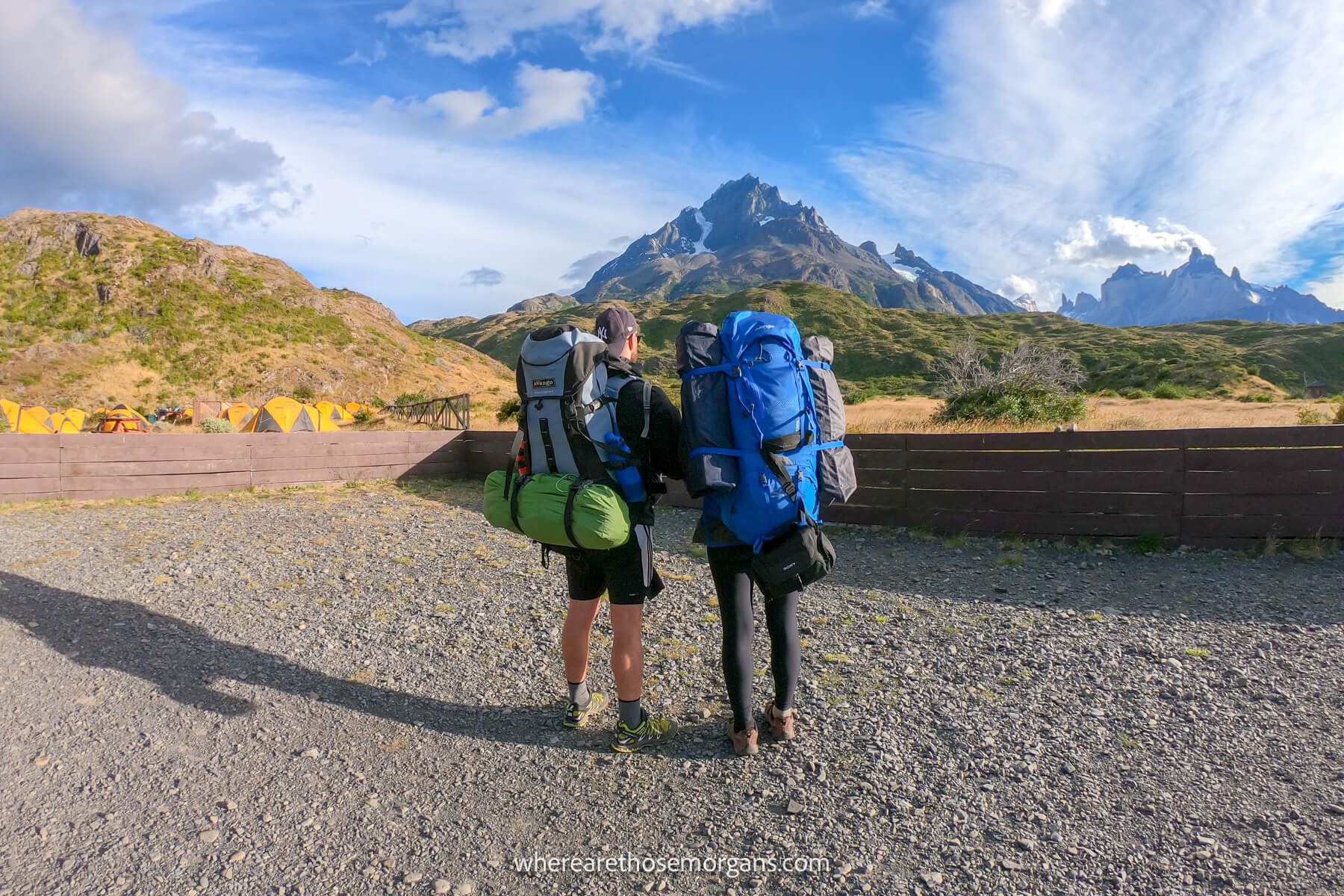 where are those morgans chile Photo of Mark and Kristen Morgan from Where Are Those Morgans standing together in hiking gear wearing huge backpacks looking at mountains and a blue sky in Torres del Paine Chile