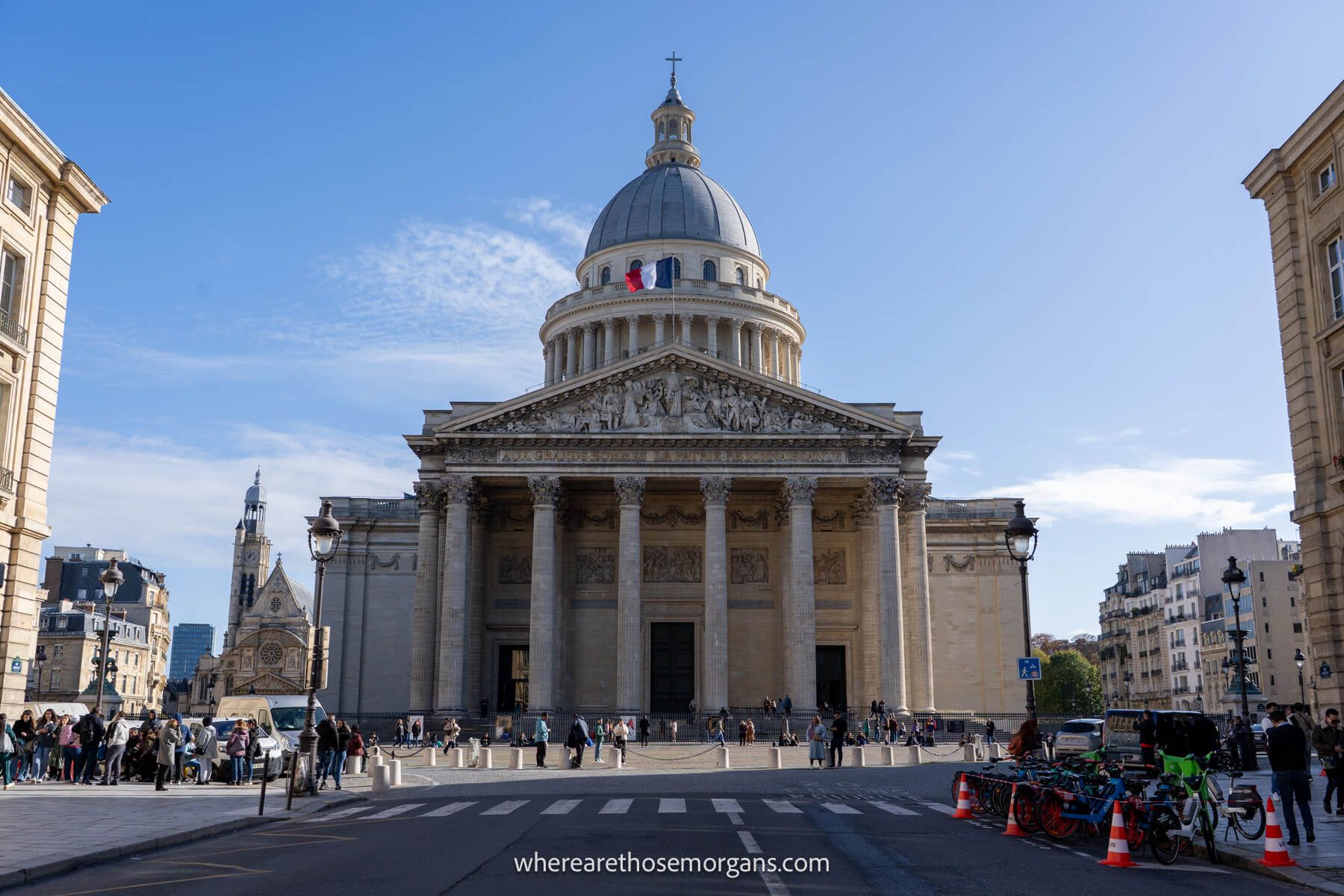 Photo of the Pantheon in Paris taken looking up a wide street to the structure on a sunny day