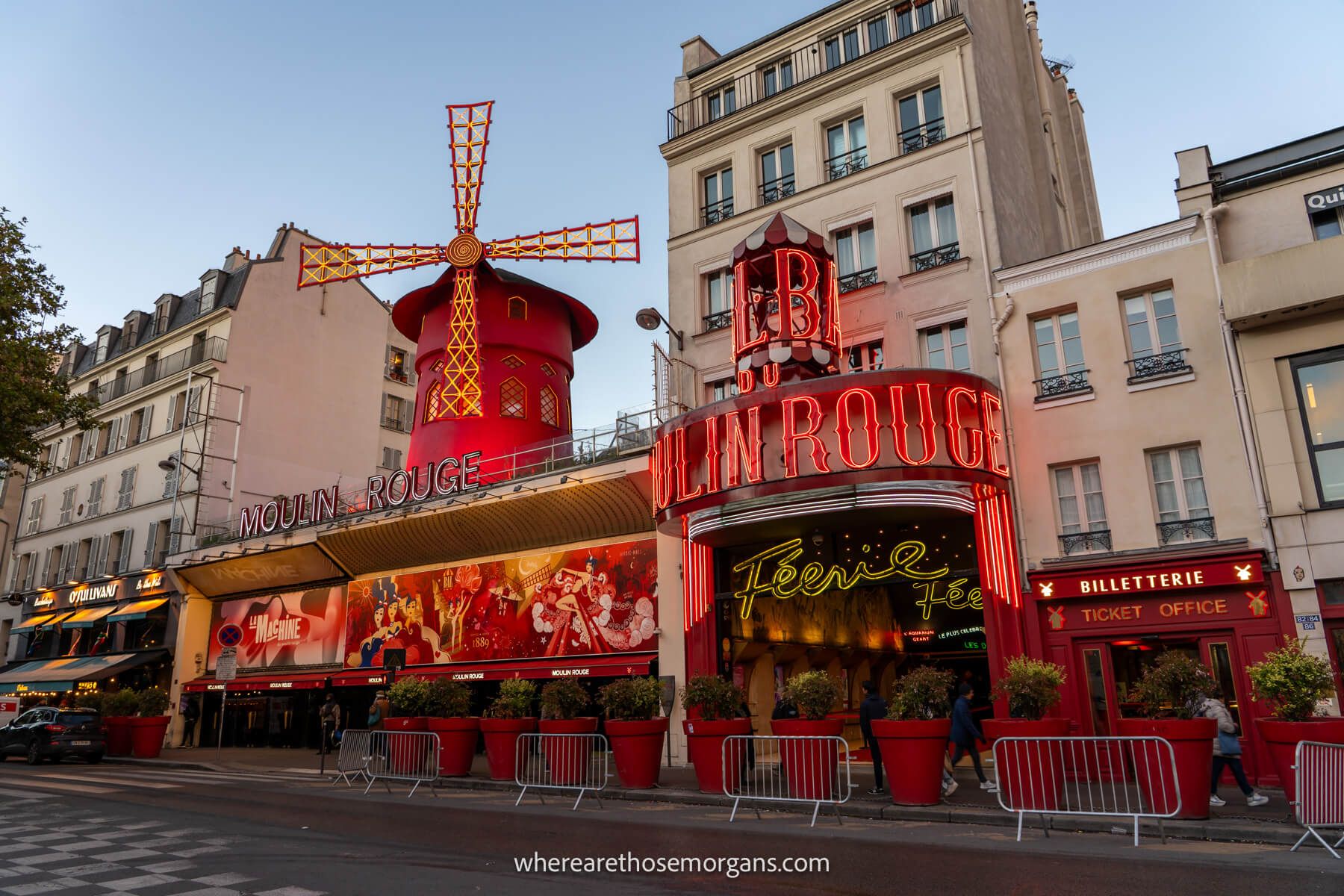 Photo of the outside of Moulin Rouge lit up at dusk with red colors