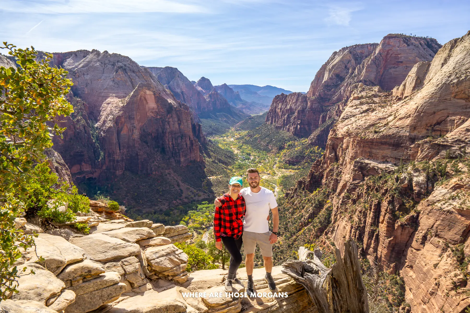 Photo of Mark and Kristen from Where Are Those Morgans standing together at the summit of Angels Landing with views over the main Zion canyon behind on a sunny day