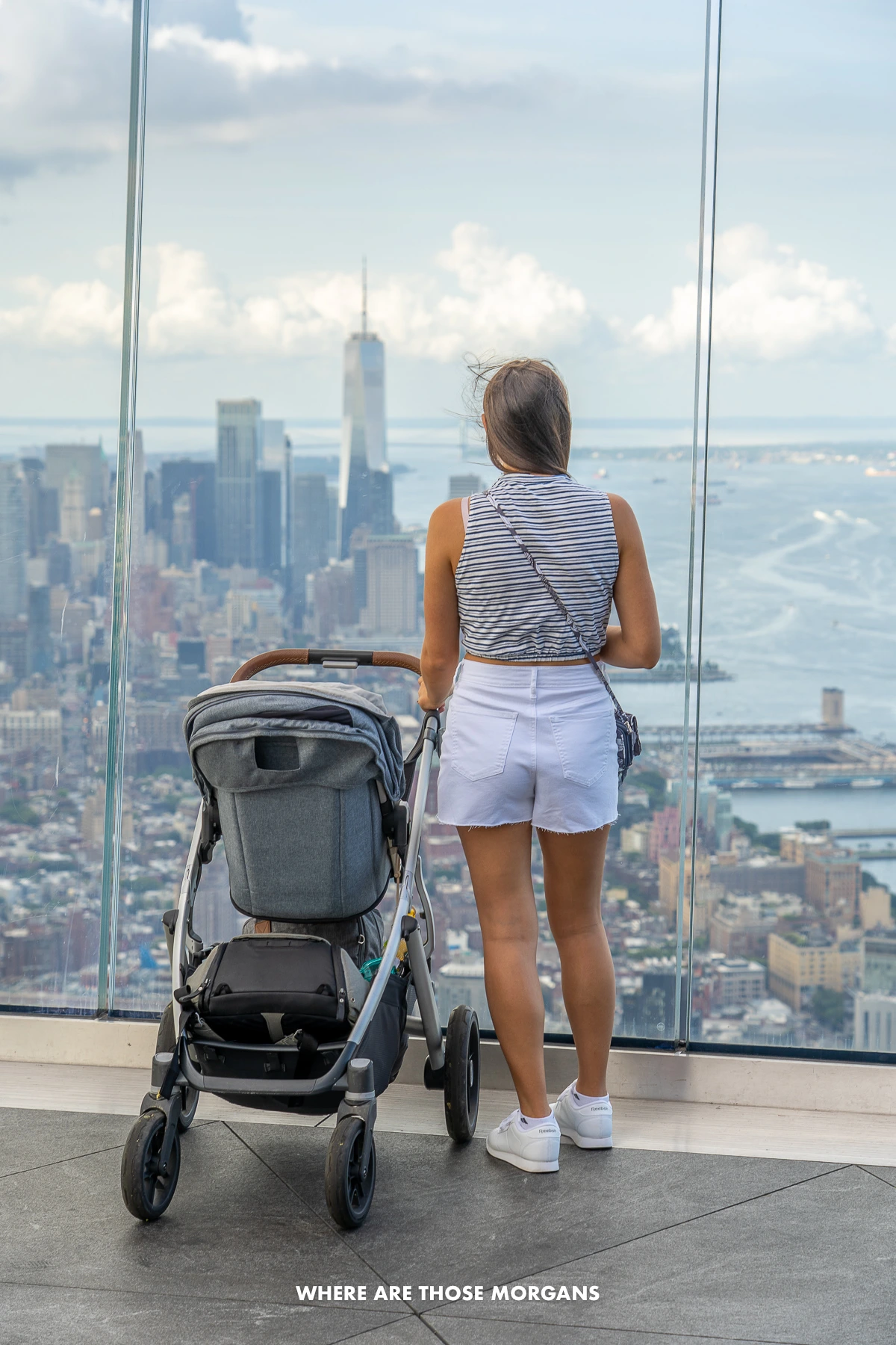 Photo of a tourist stood next to a stroller on the observation deck at Edge Hudson Yards on a cloudy day