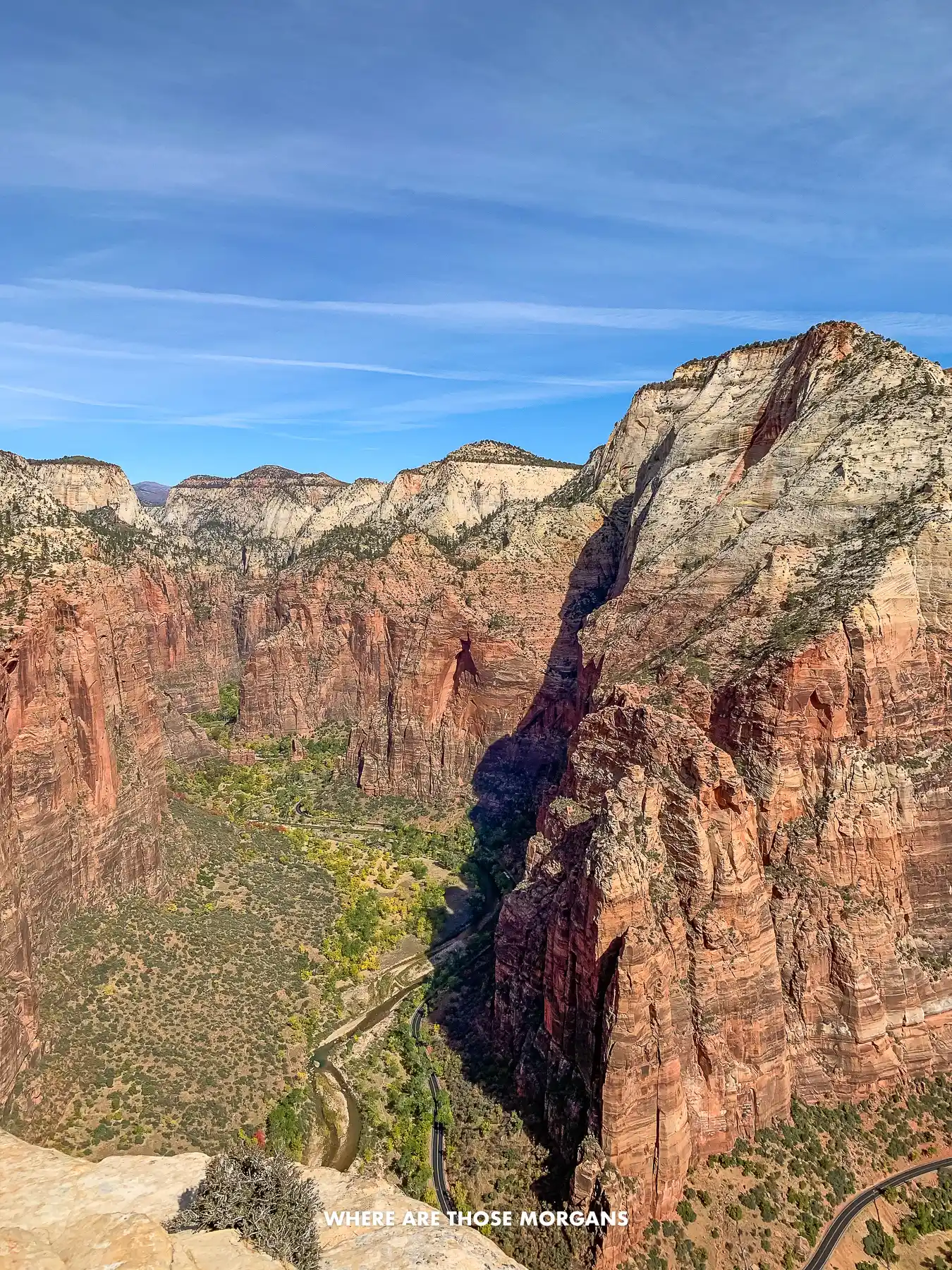 Photo of towering red rock cliffs with enormous drop offs on a sunny day in Utah