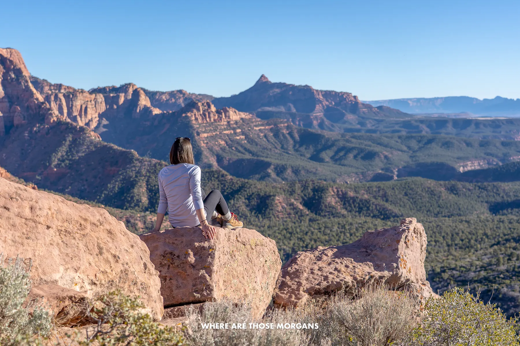 Photo of Kristen sat on a boulder looking at views over Kolob Canyons