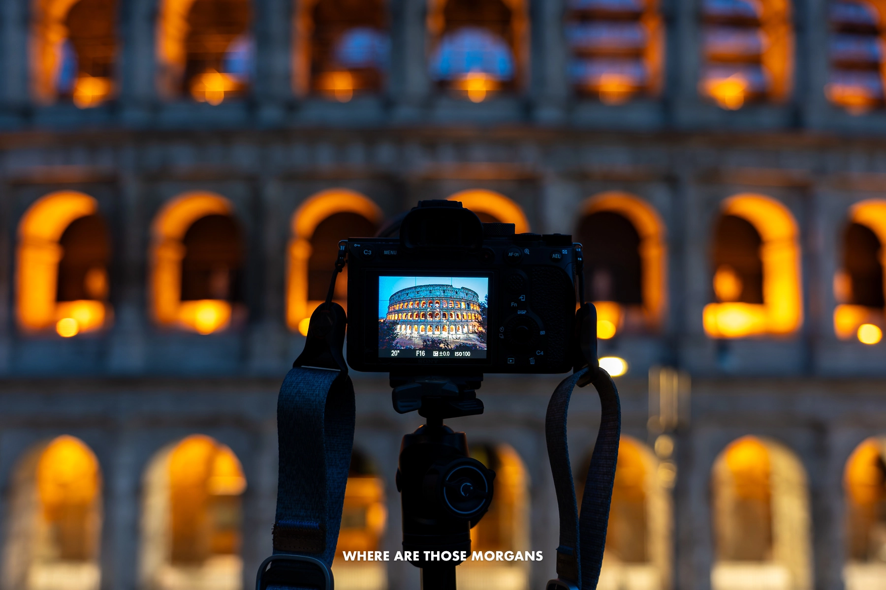 Photo of a camera taking a photo of the Colosseum at night