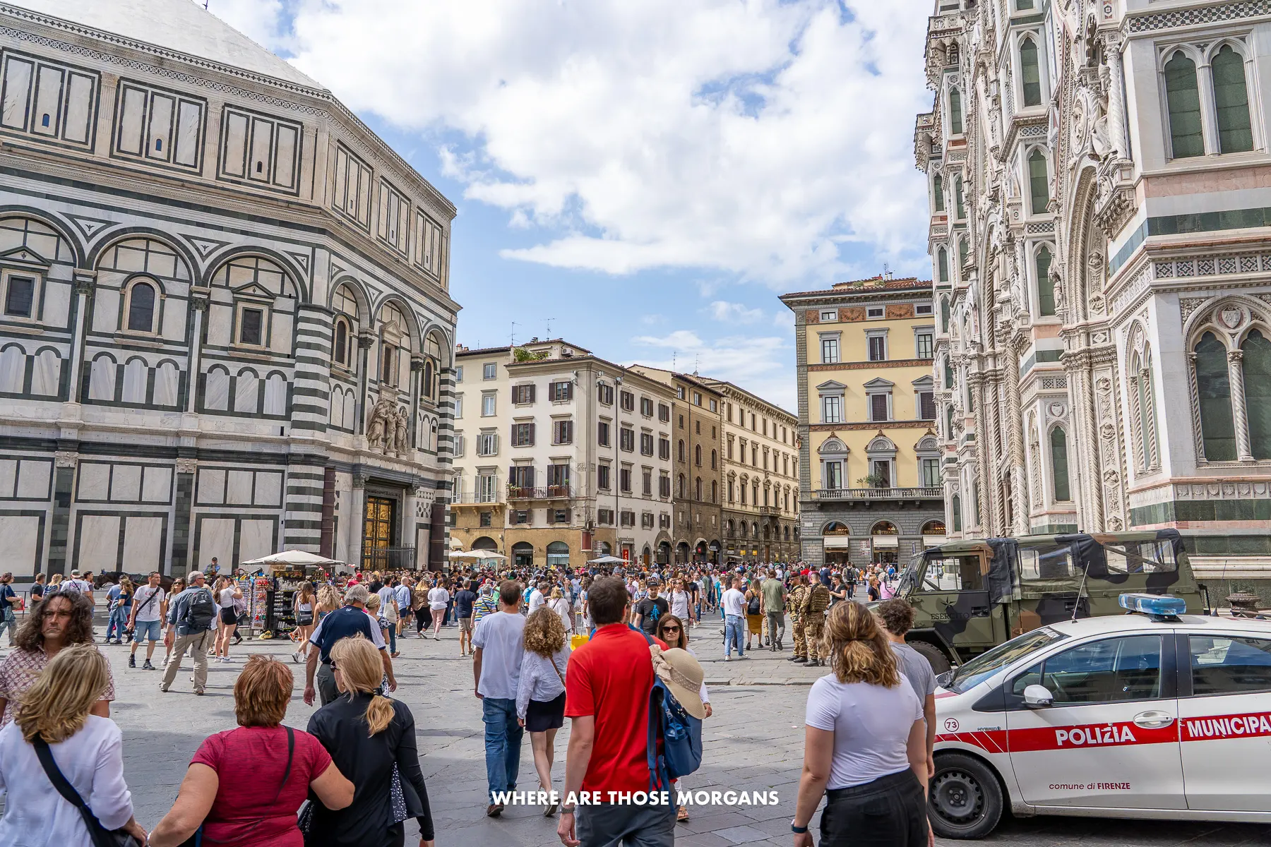 Photo of people walking through streets with Renaissance buildings to either side in Italy