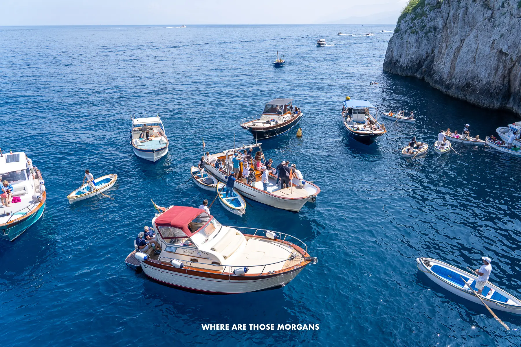 Photo of several boats anchored next to a headland in Italy
