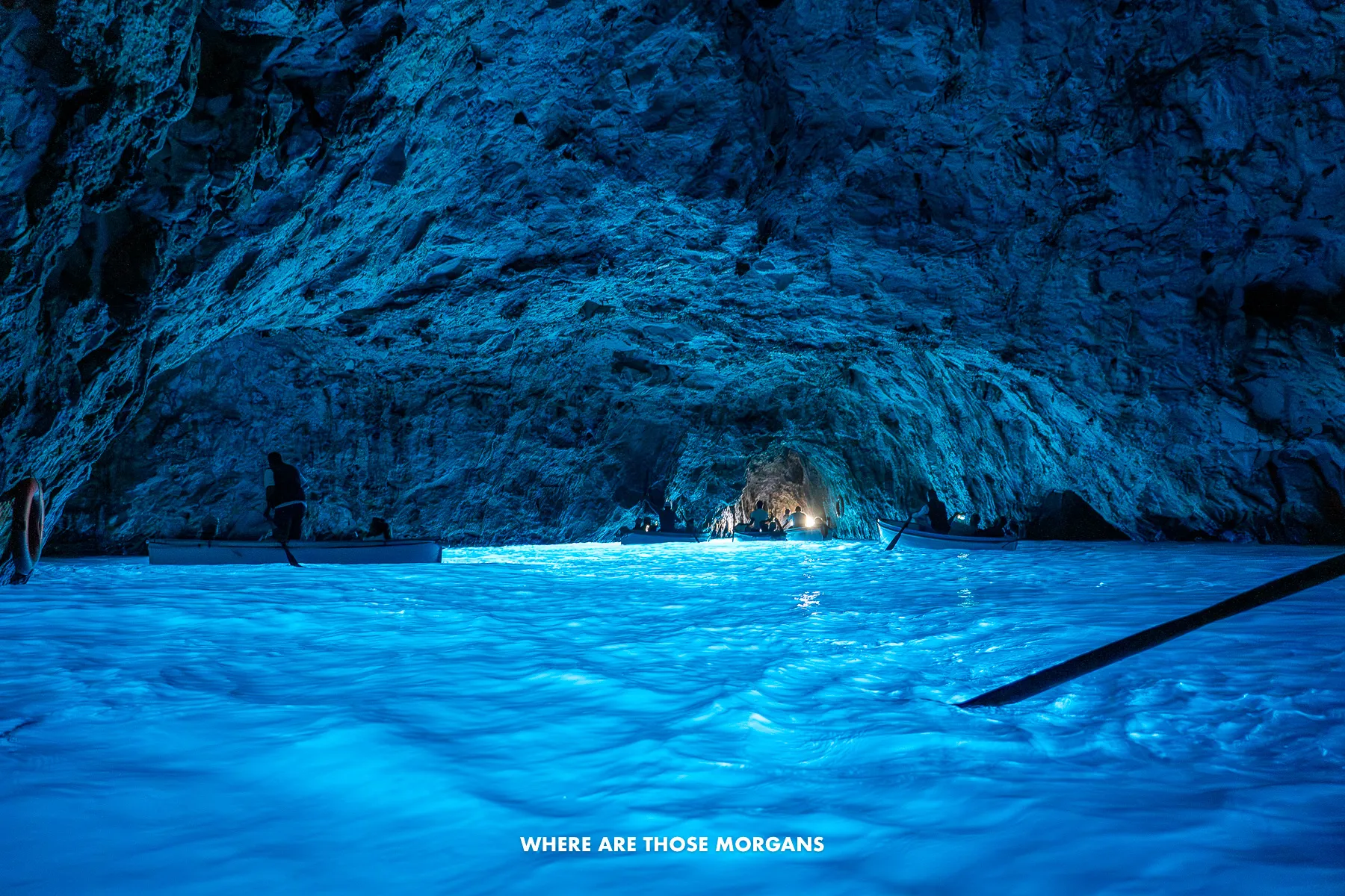 Photo of deep blue water inside a small sea cave in Italy