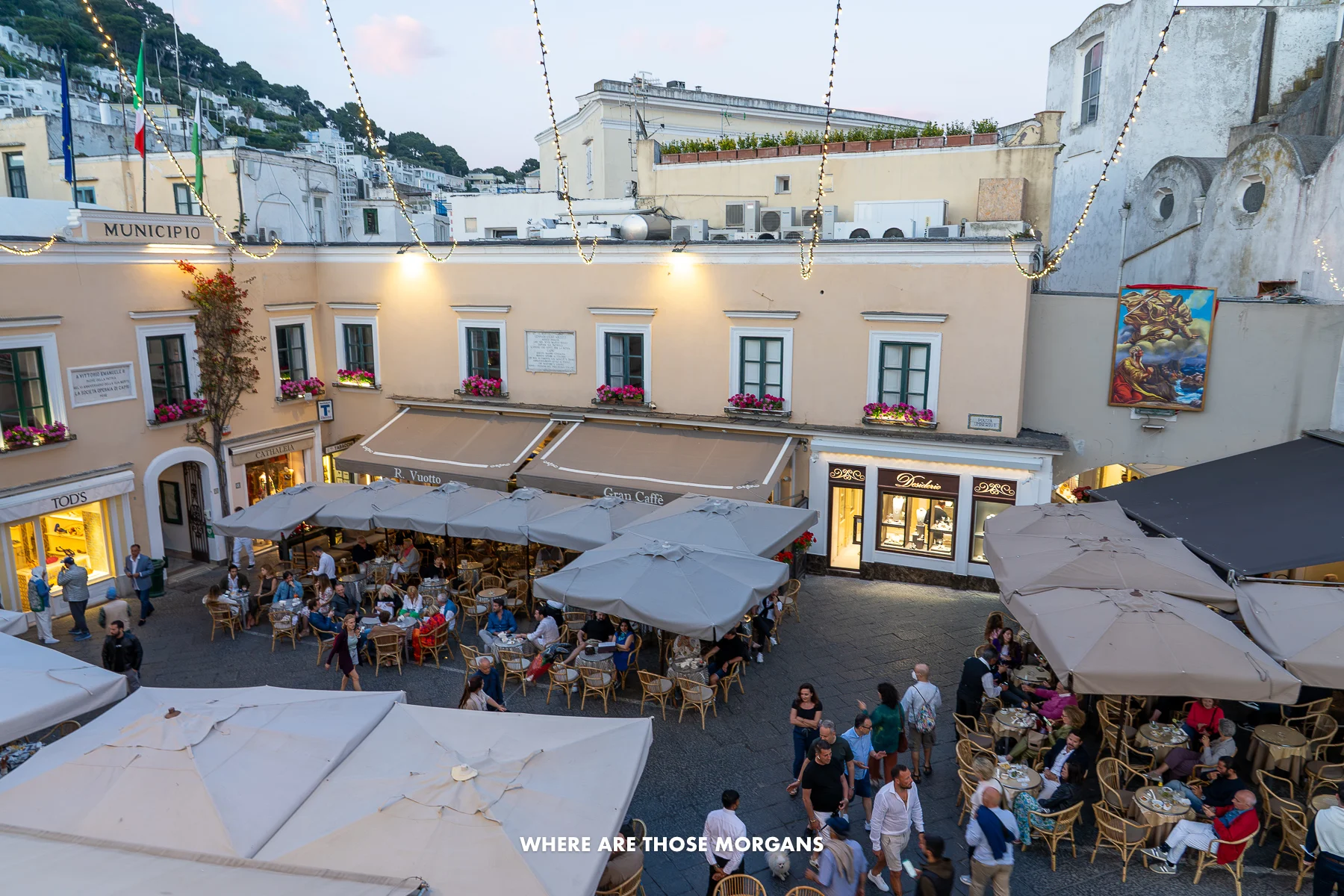 Photo looking down onto the main square in Capri town with all the tourists sat eating and drinking under canopy and lights