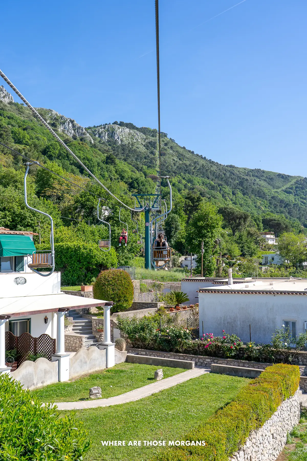 Photo of the chair lift to Monte Solaro in Capri going low over a house and garden on the way to the mountain summit