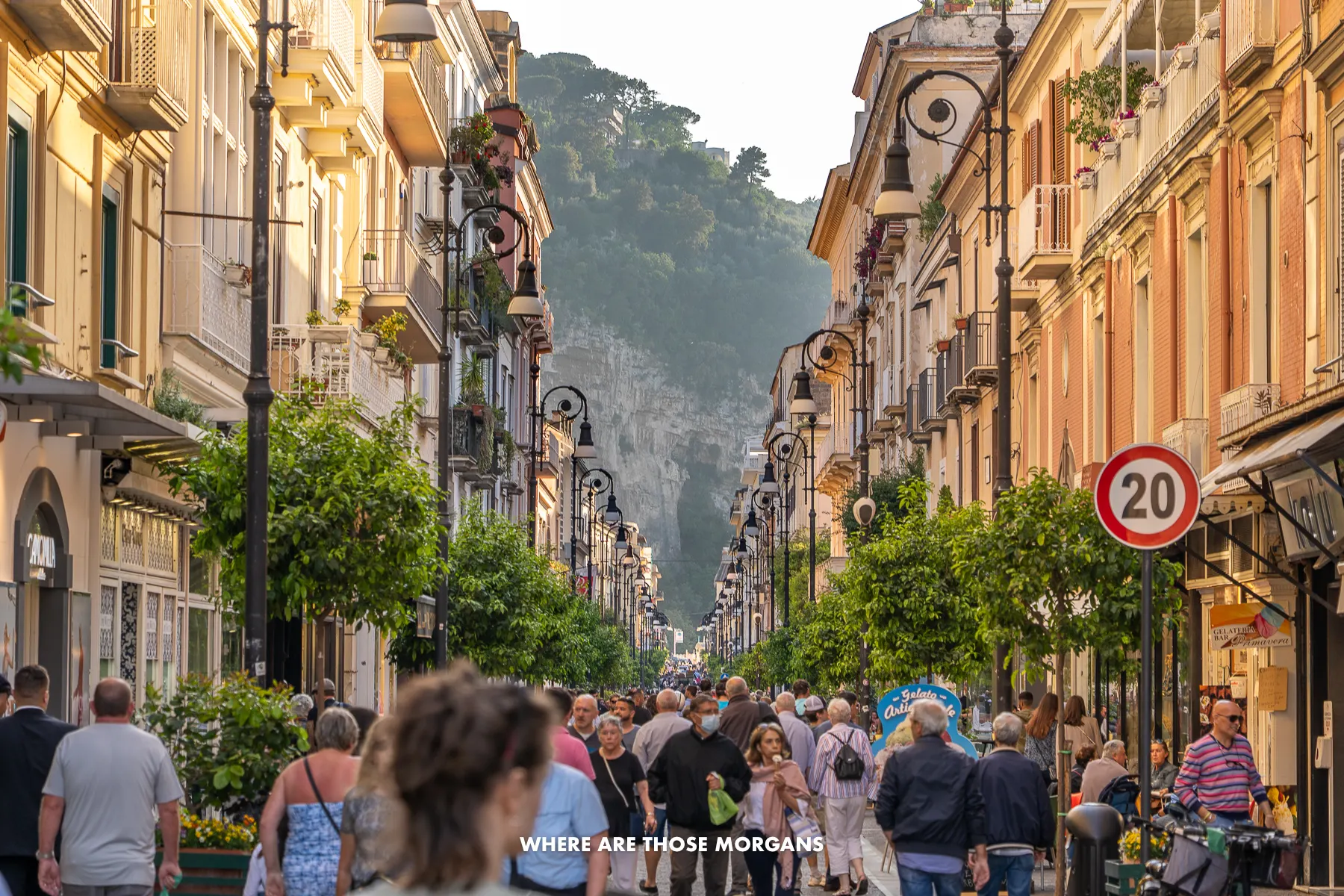 Photo of a long, straight and wide shopping street in Sorrento, Italy with crowds of people walking through