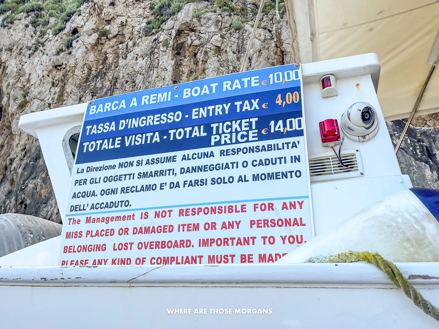 Photo of a sign attached to a boat stating the prices for going inside a sea cave in Italy