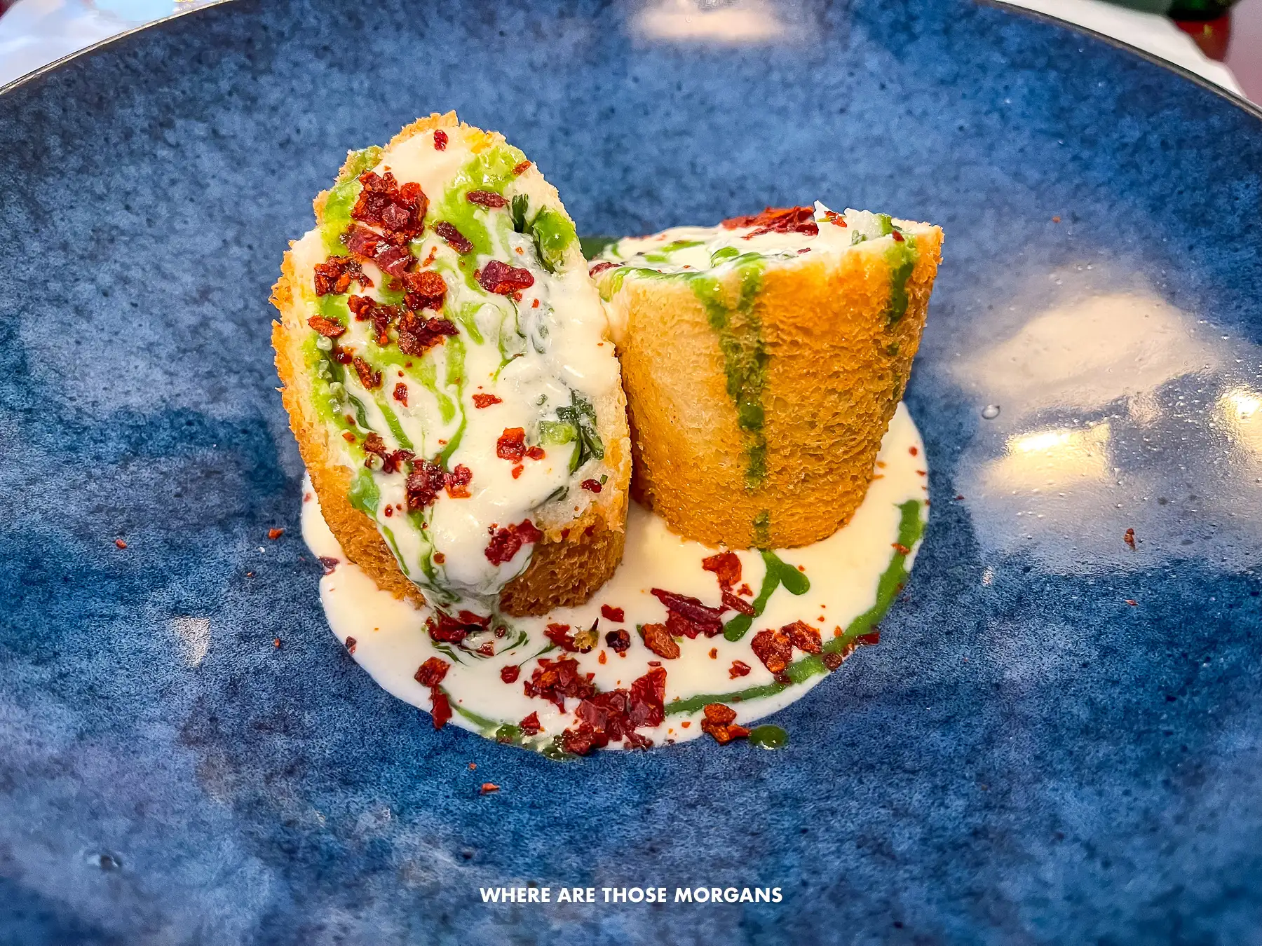 Photo of a blue plate with a small portion of well presented food