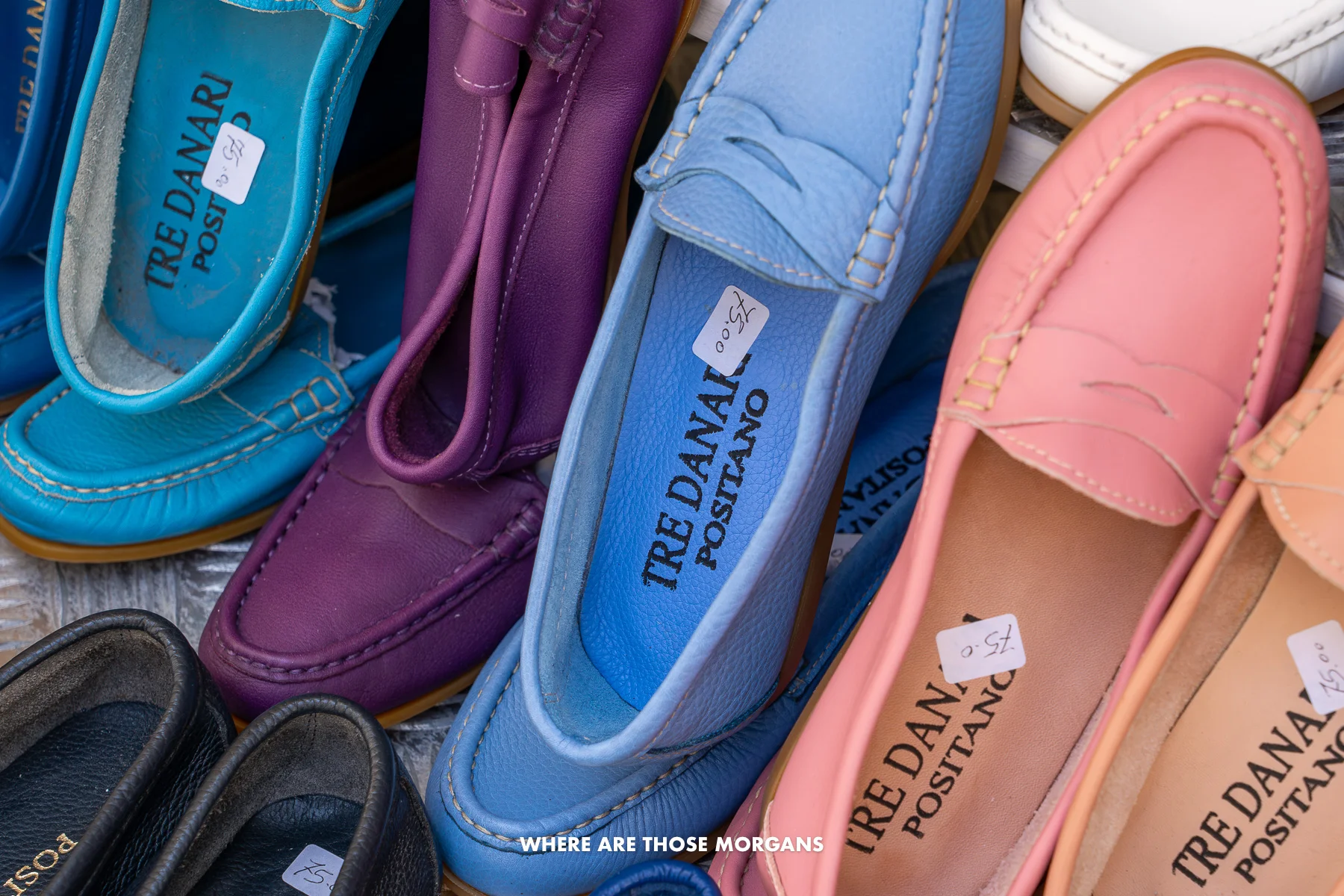 Photo of colorful leather shoes hanging next to each other with a 75 euro price tag