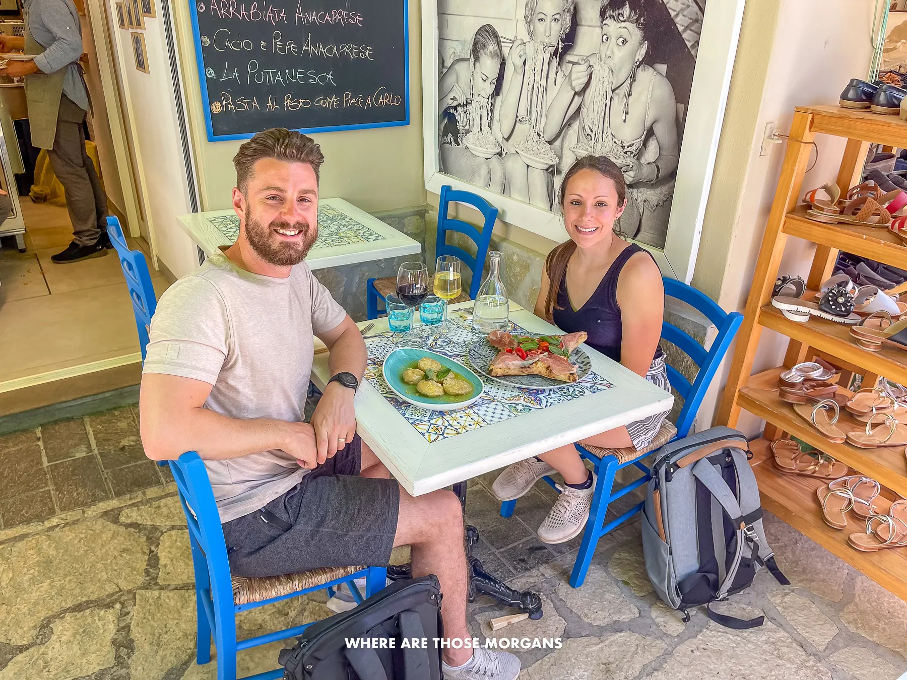 Photo of Mark and Kristen from Where Are Those Morgans sitting together for lunch at a small table outside in the sun in Italy
