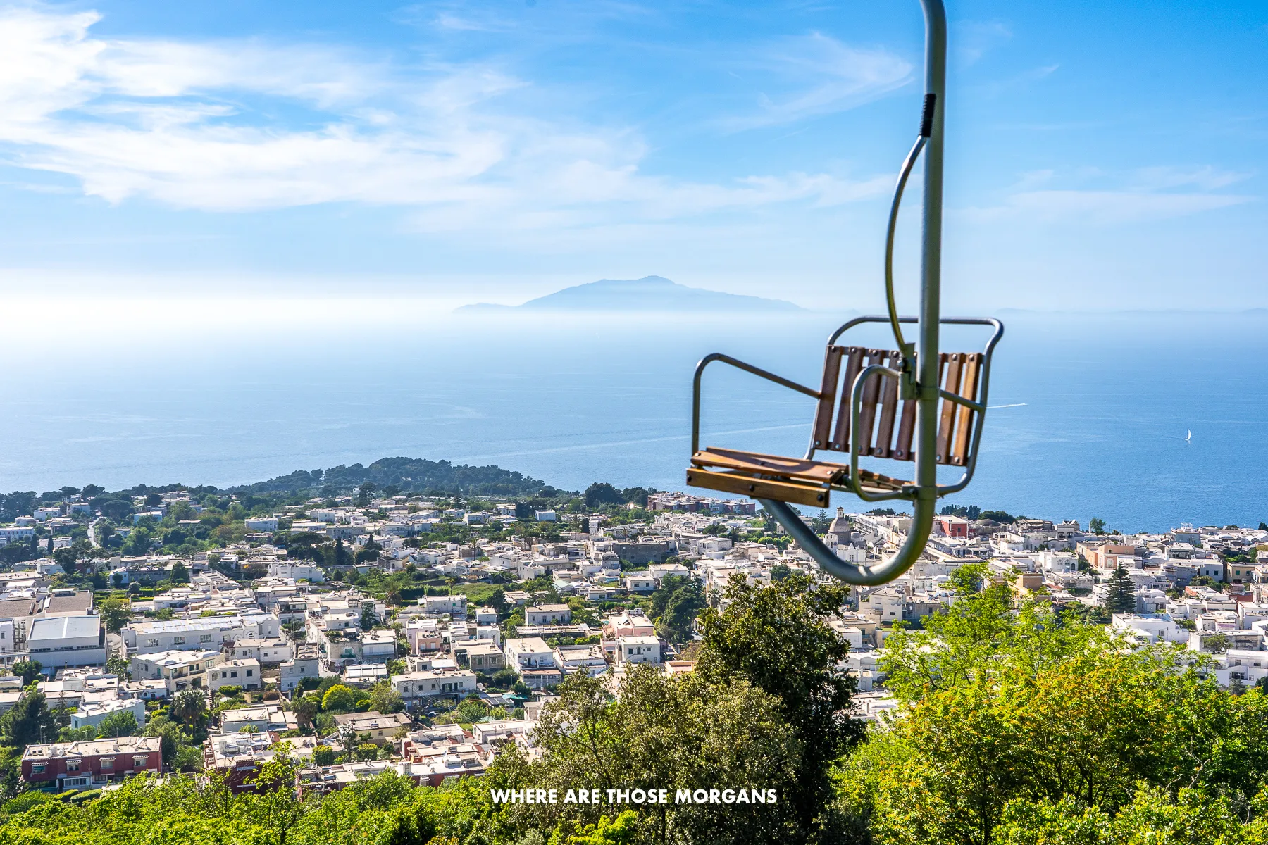 Photo of Anacapri and Ischia with one of the Monte Solaro chair lifts passing by on a sunny day