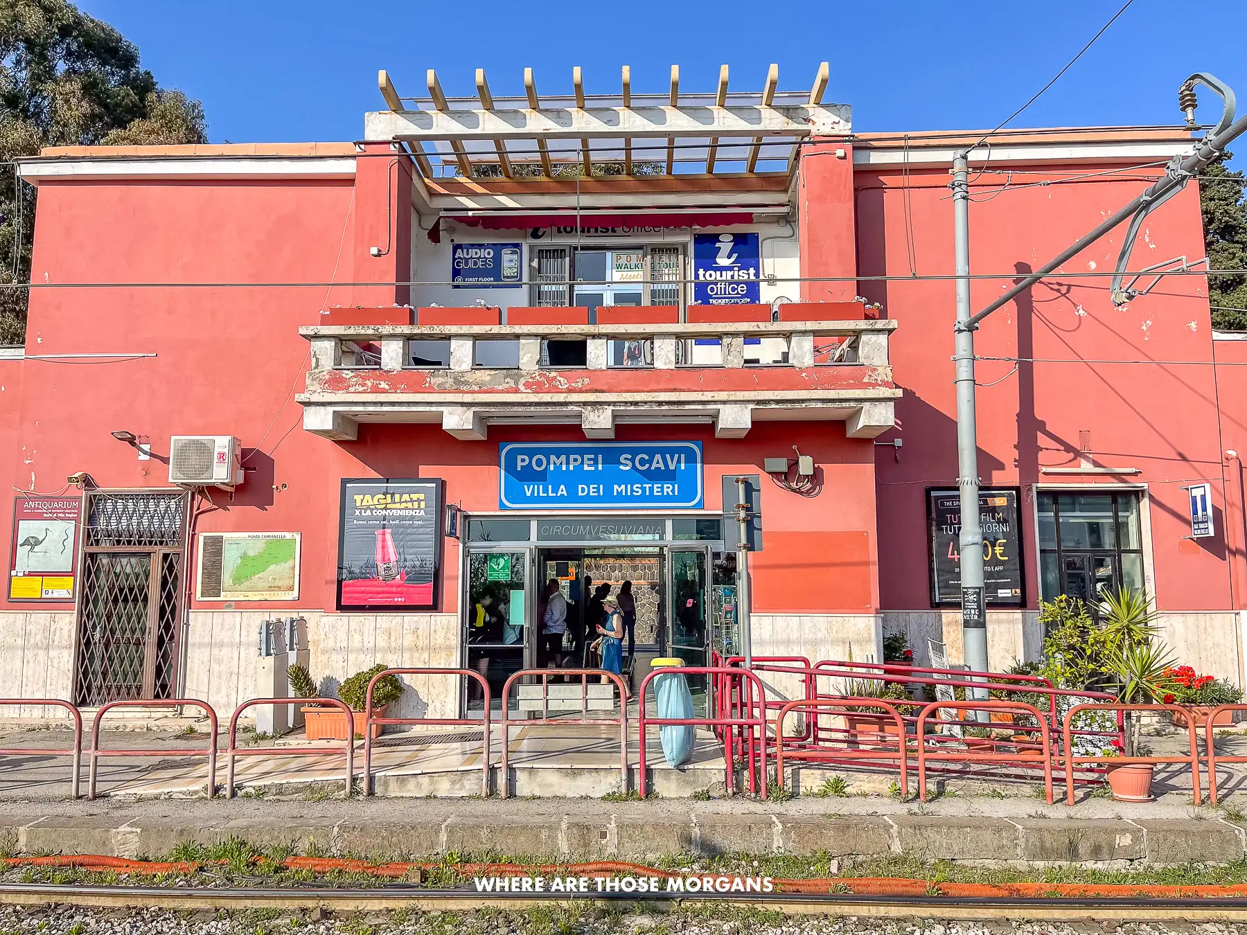Photo of Pompei Scavi train station with its coral red colored walls from the outside