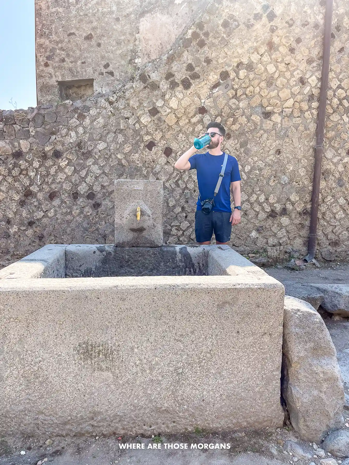 Photo of Mark from Where Are Those Morgans drinking water from a fountain in a ruin in Italy
