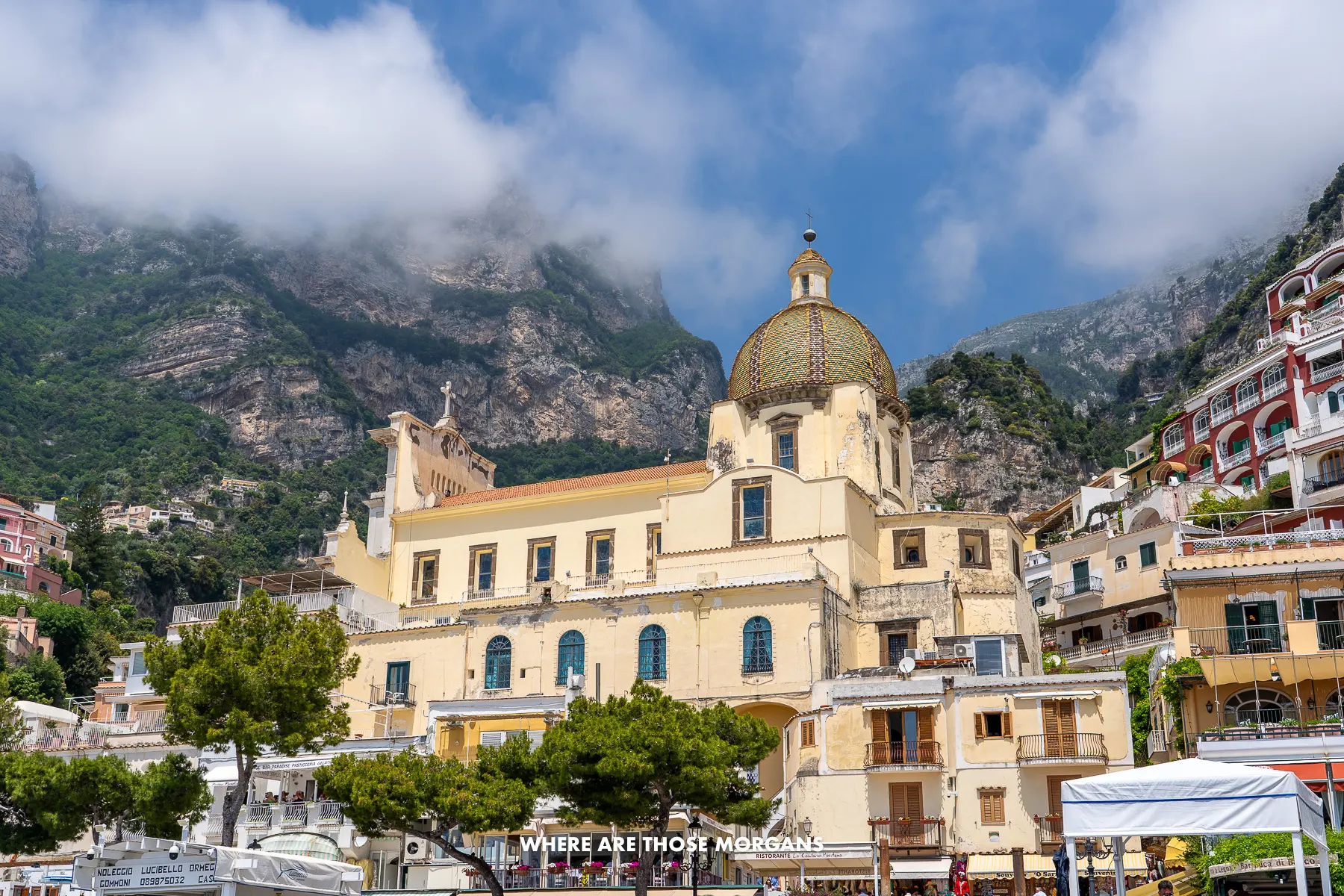 Photo of the Church of Santa Maria Assunta taken from Spiaggia Grande in Positano with views of the tall cliffs behind