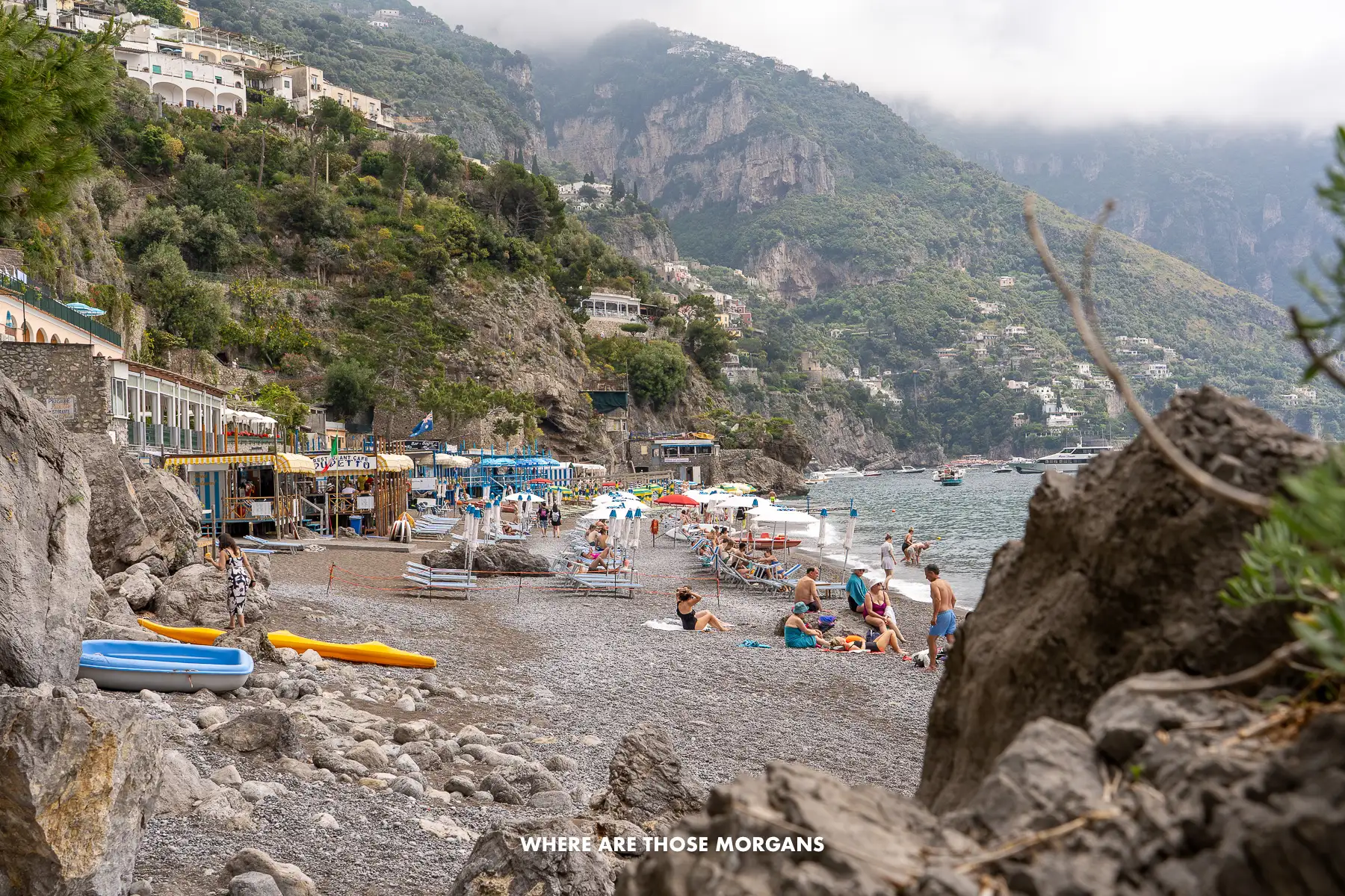 Photo of a pebble beach taken from behind rocks on the Amalfi Coast in Italy