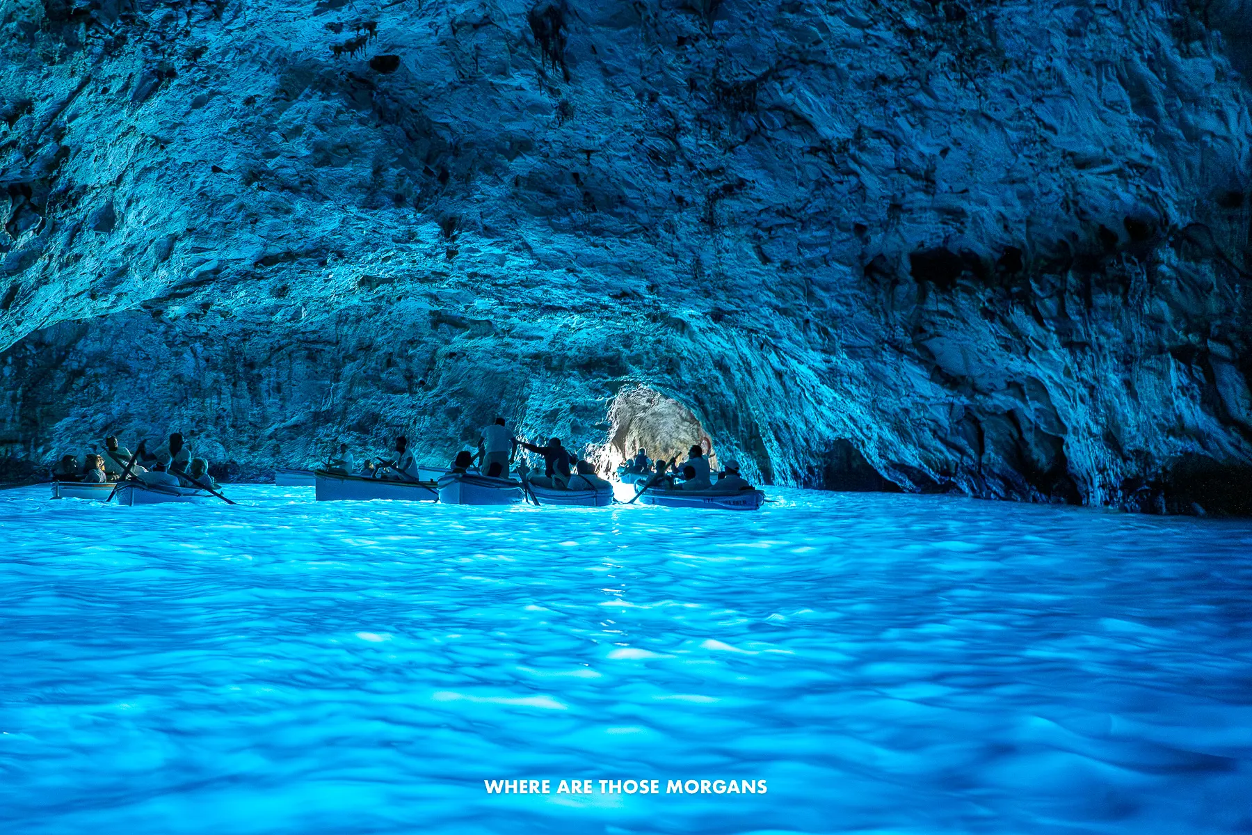 Photo of the inside of Capri's Blue Grotto with light naturally bouncing off water and illuminating the sea cave