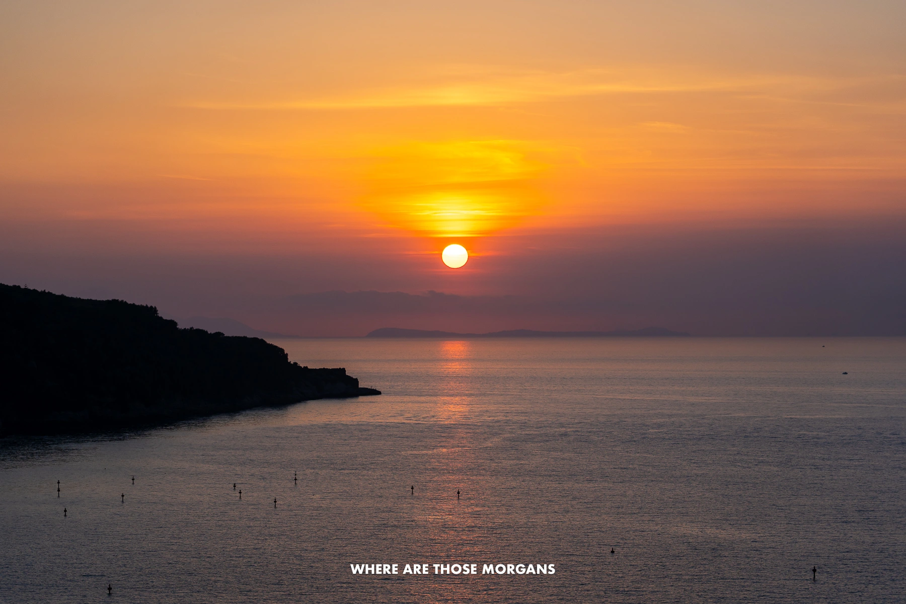 Photo of the sun setting over the Gulf of Naples in Italy with colorful clouds in the sky