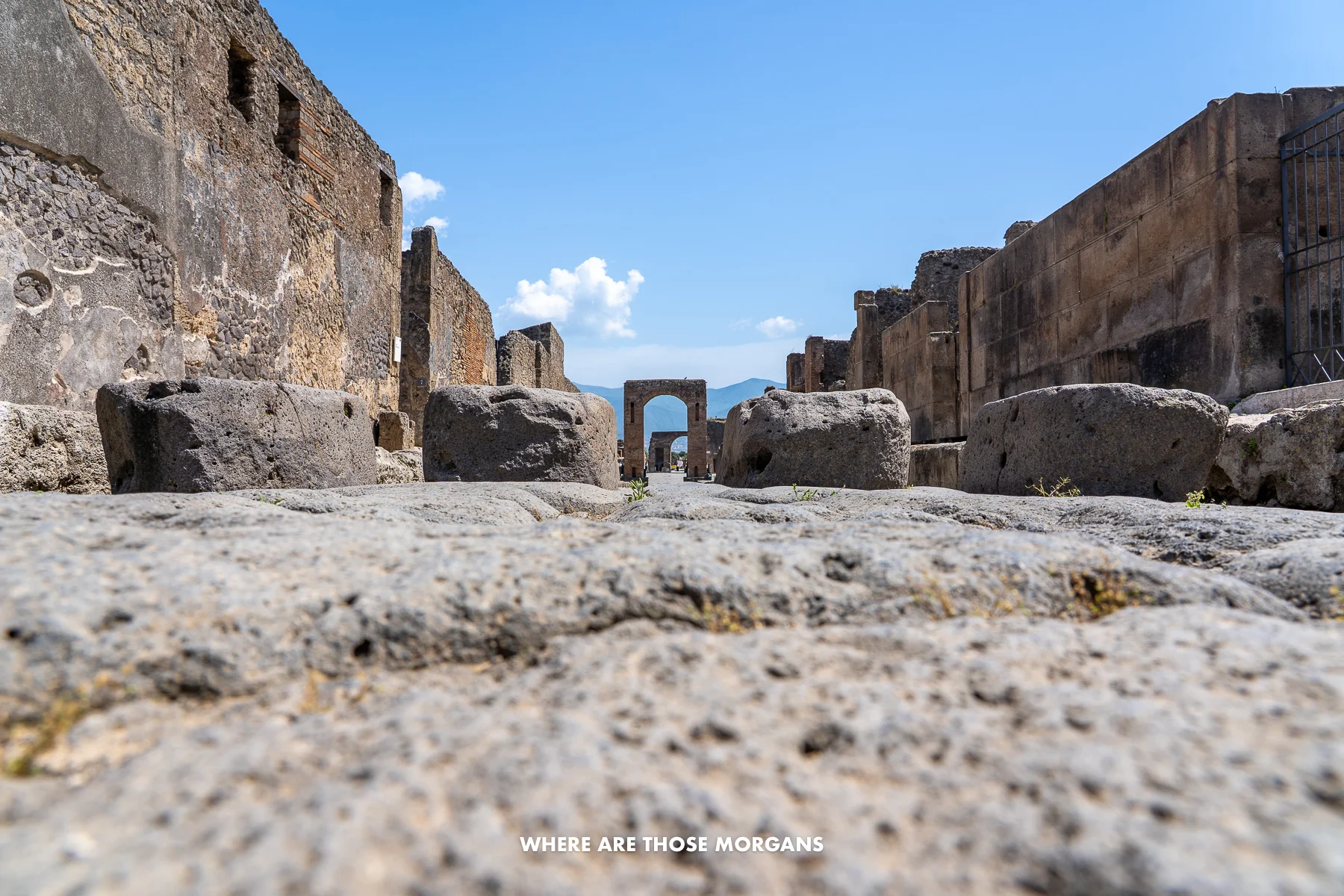 Photo of a narrow street in Pompeii taken from the ground to show stepping stones as a raised crosswalk